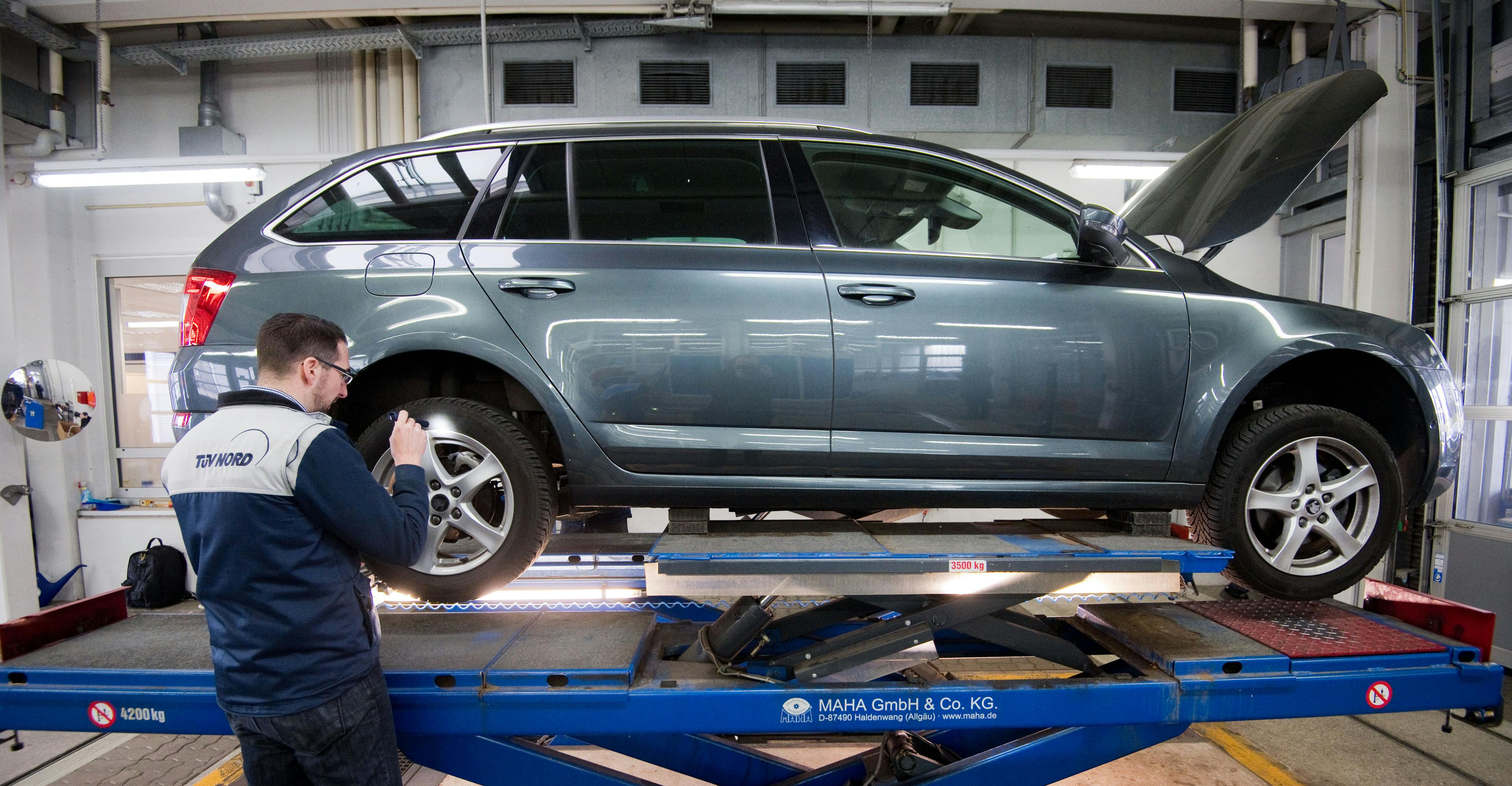 Auto steht in einer Werkstatt auf einer Hebebühne