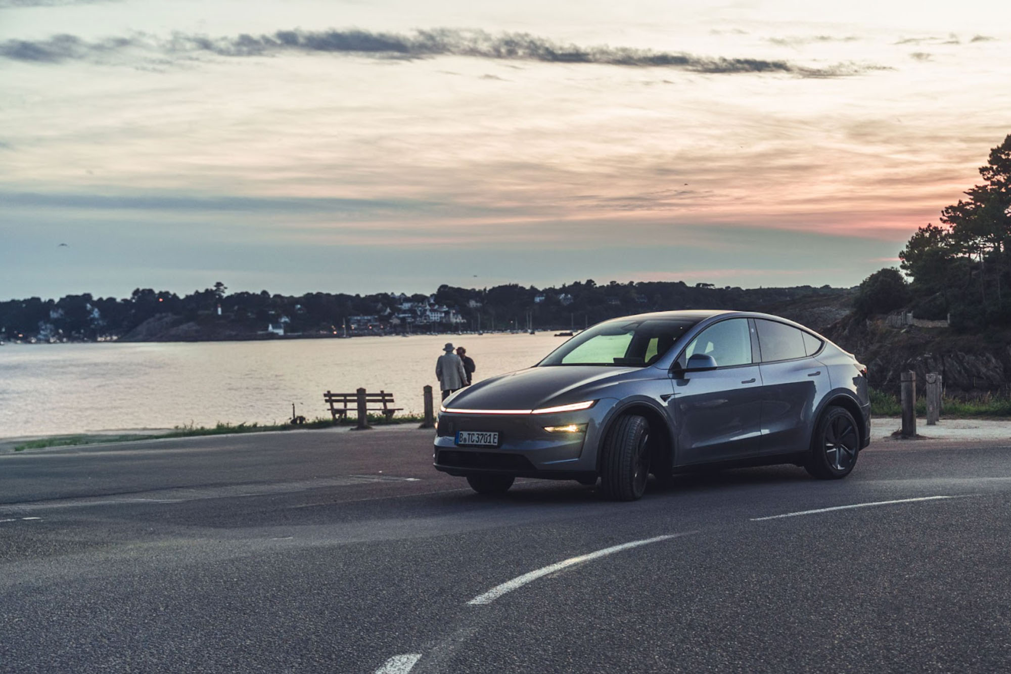  Ein dunkelgraues Tesla Model Y parkt vor malerischer Kulisse am Meer