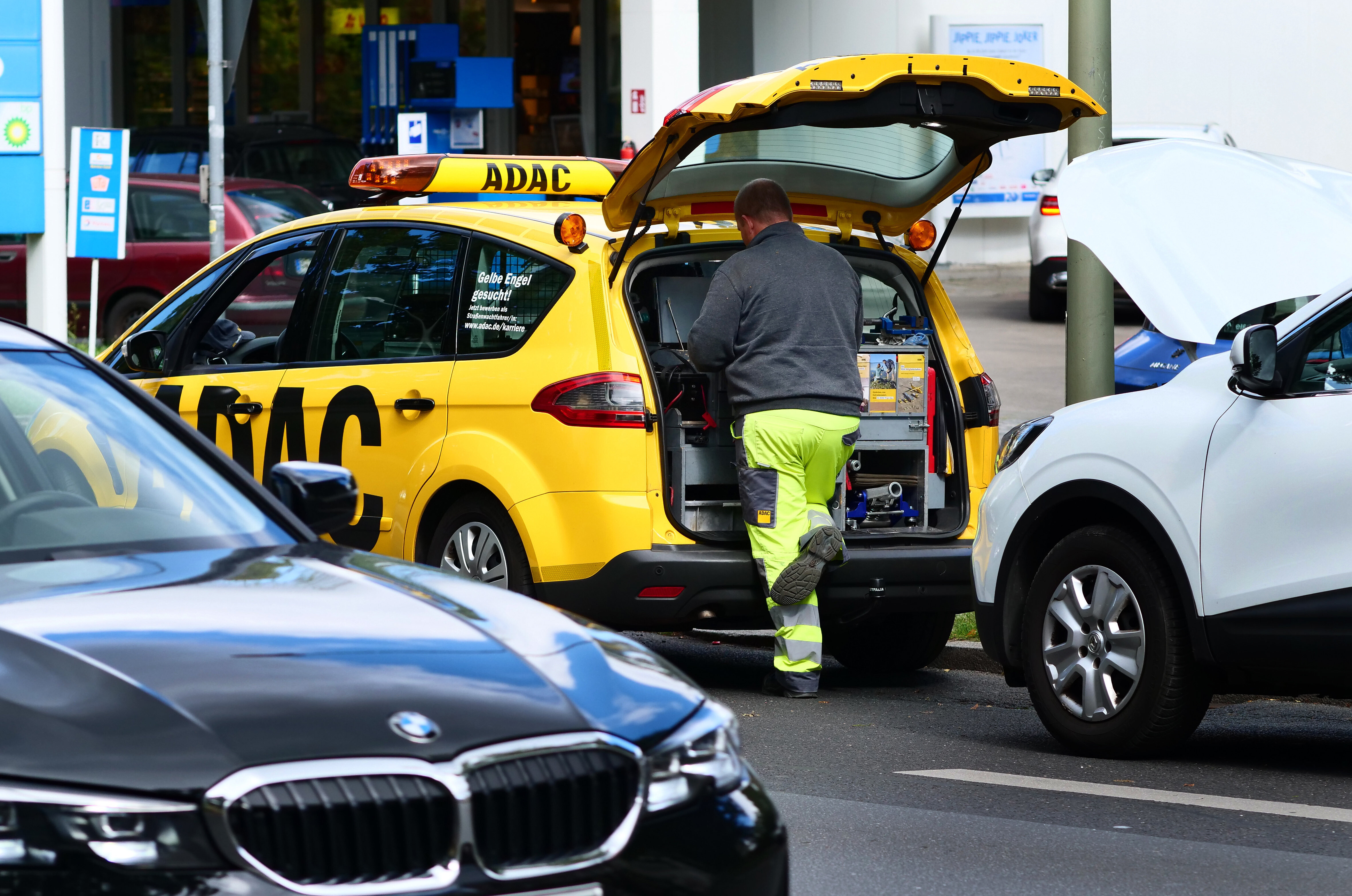 Ein ADAC-Pannenhelfer leistet einem Autofahrer bei einer Panne Hilfe und kümmert sich um das Abschleppen.