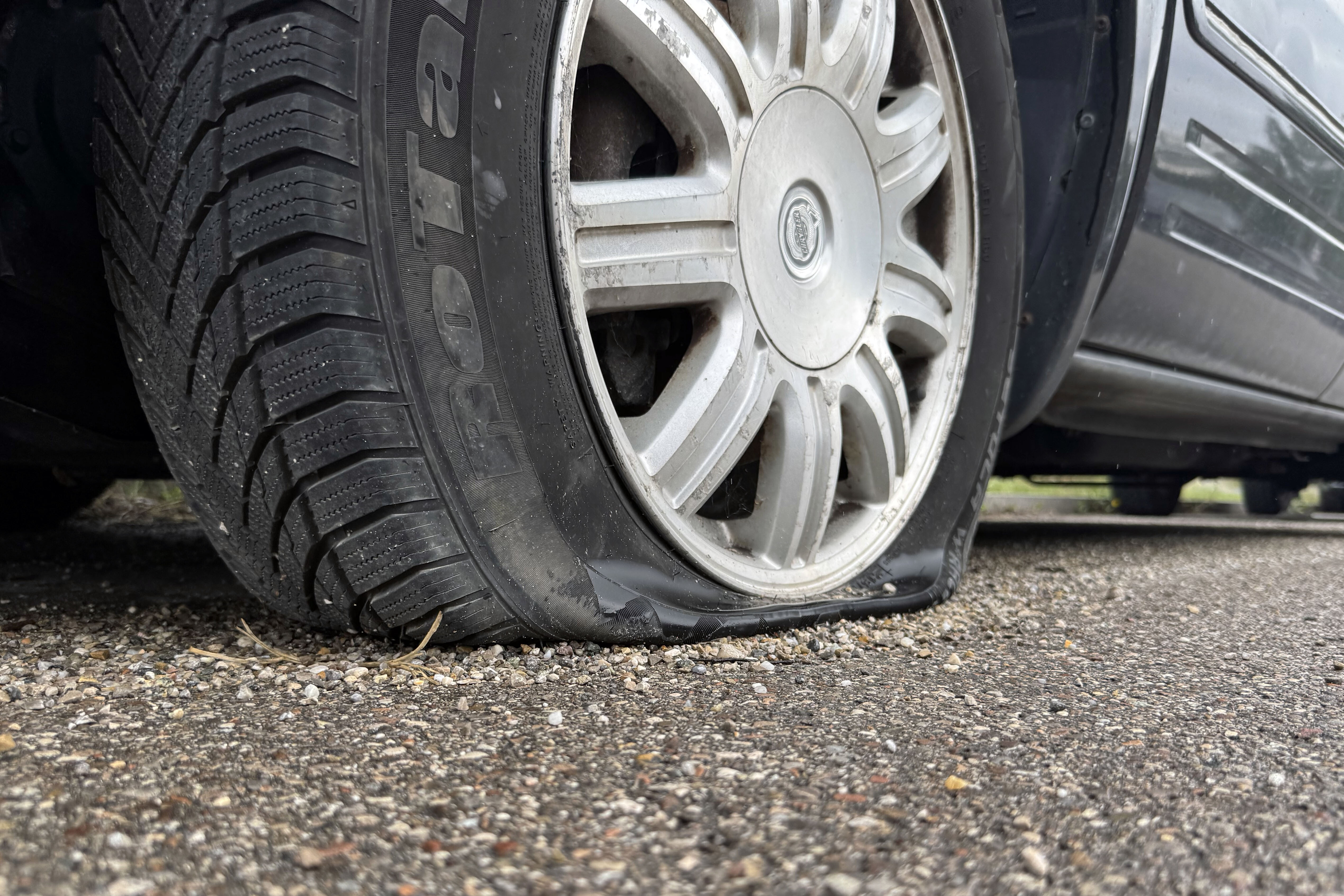 Ein dunkles Fahrzeug hat einen platten Reifen.