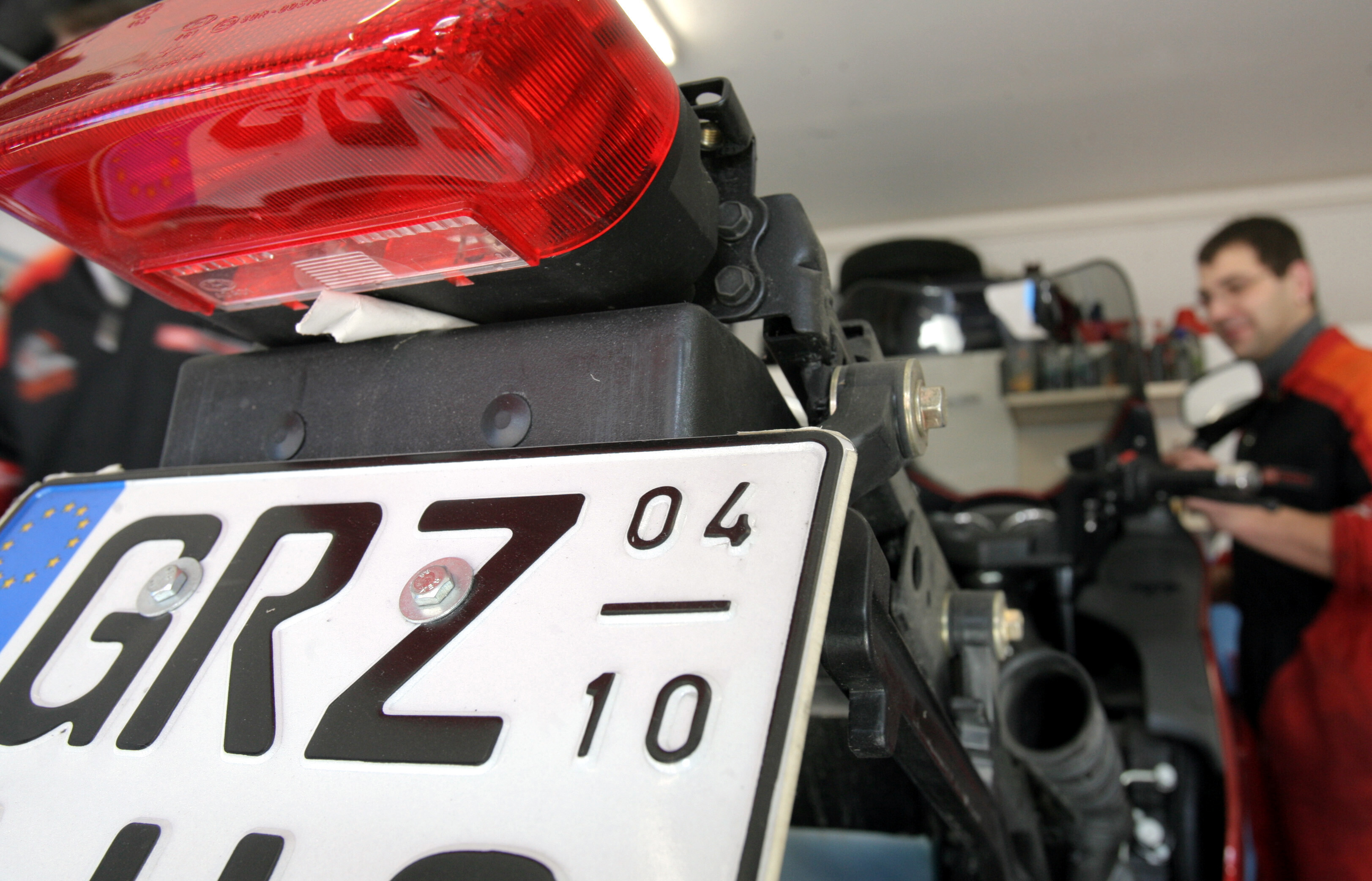 Nahaufnahme eines Saisonkennzeichens an einem Motorrad, das von April bis Oktober gültig ist.