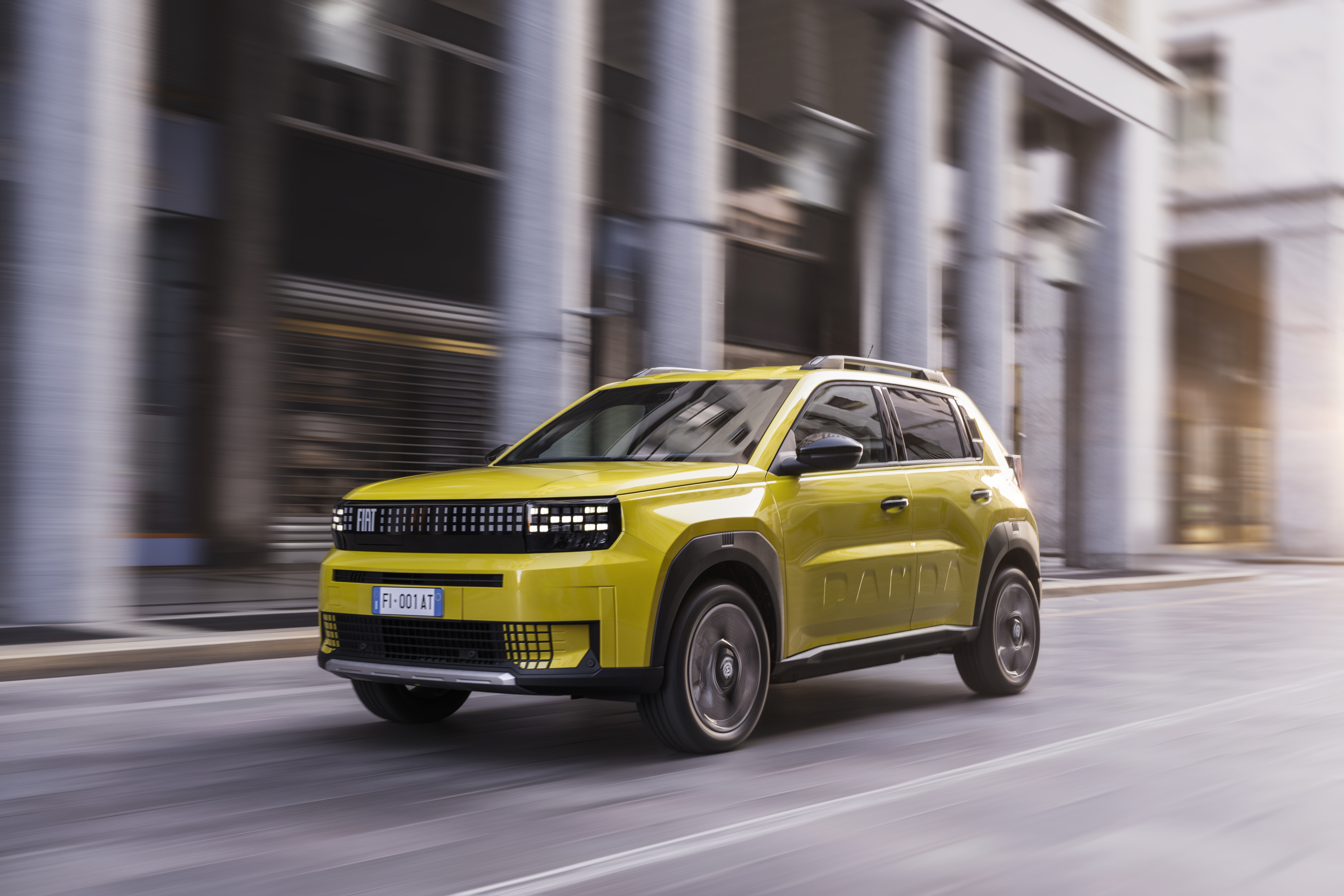 Ein gelber Fiat Grande Panda fährt auf einer Straße.