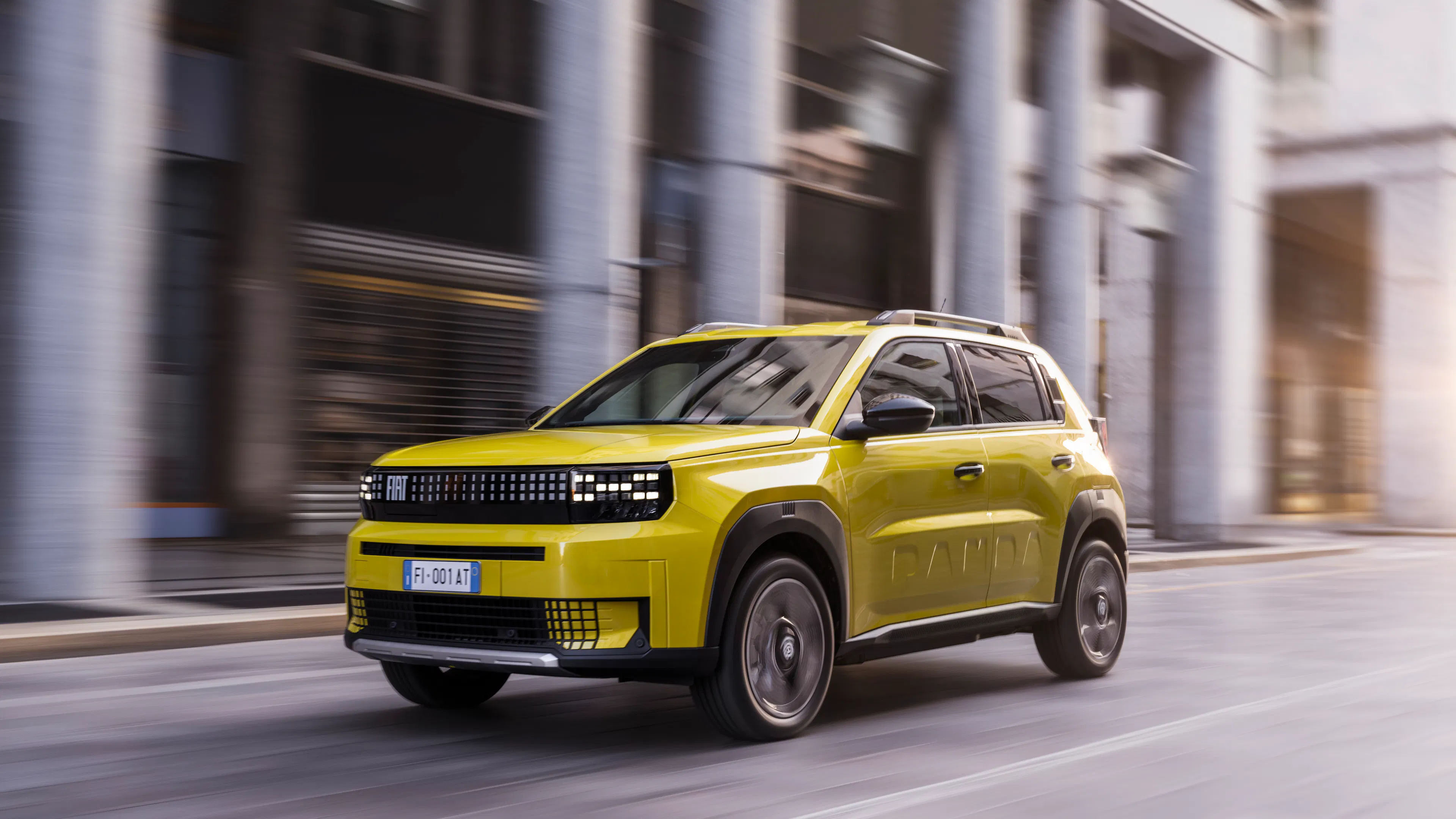 Ein gelber Fiat Grande Panda fährt auf einer Straße.