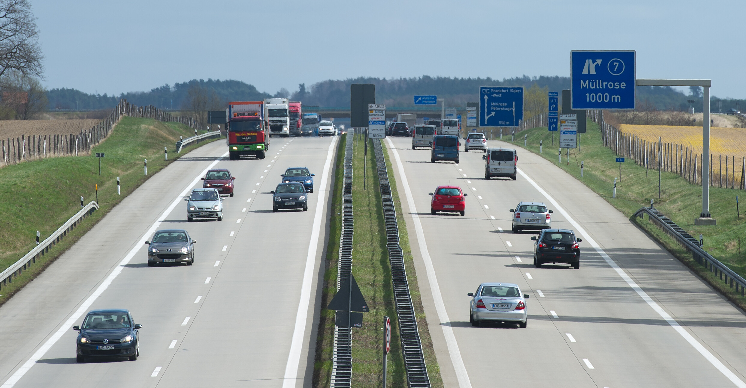 Mehrere Fahrzeuge passieren auf der Autobahn ein Schild mit der Aufschrift "Müllrose".