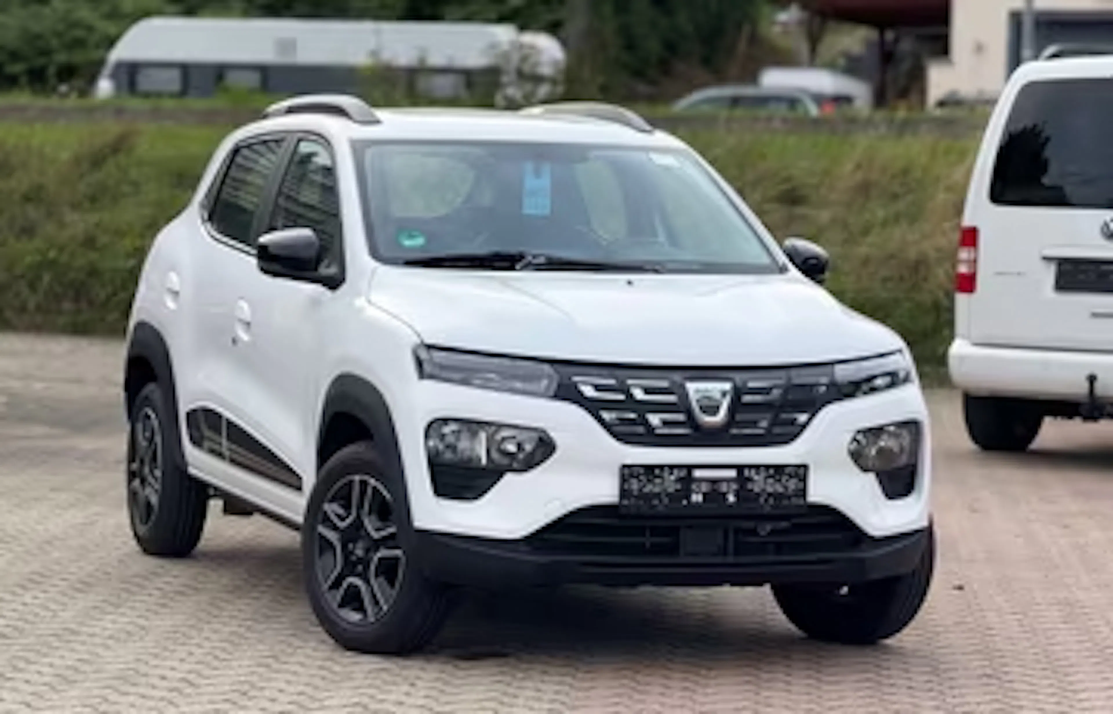 Weißer Dacia Spring auf einem Parkplatz