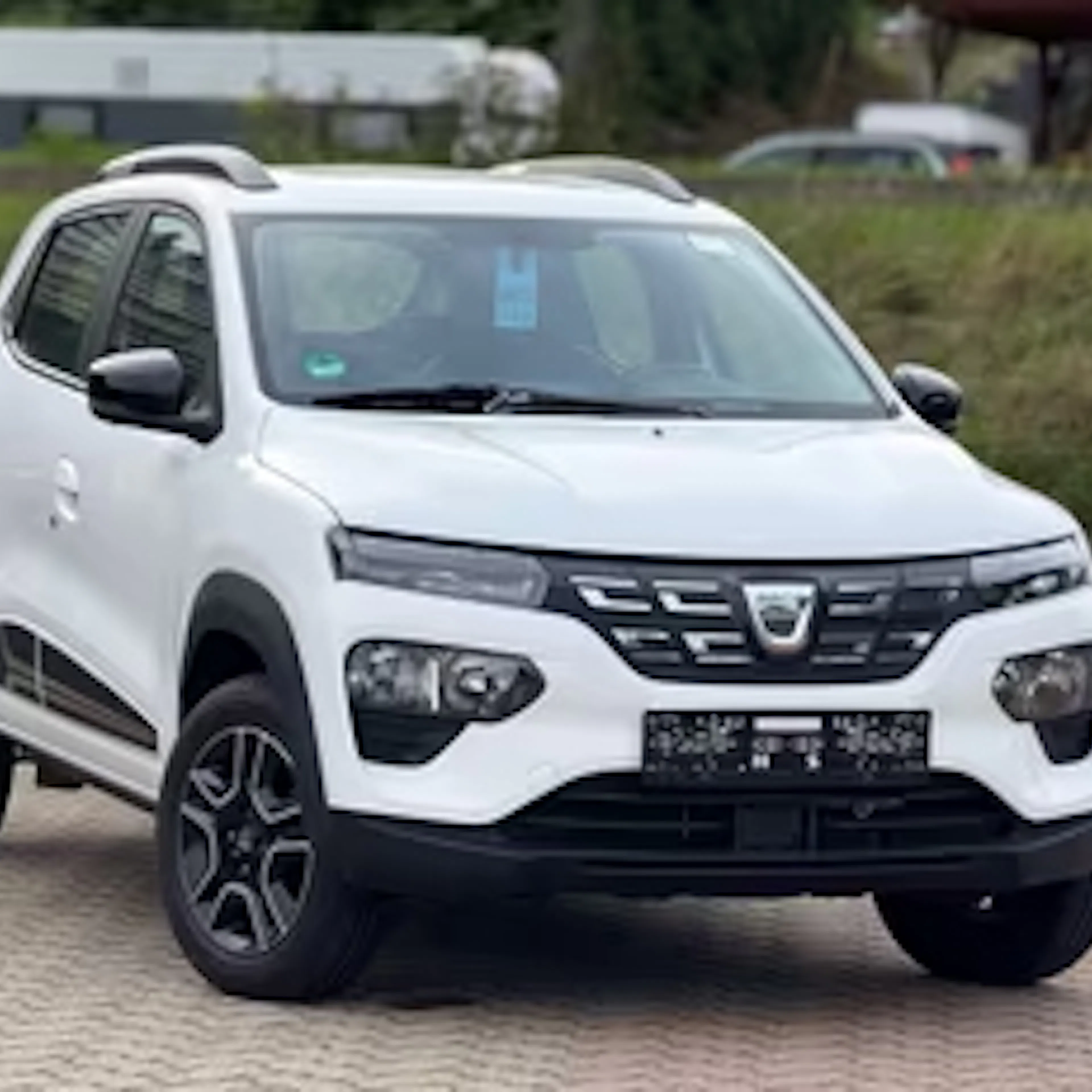 Weißer Dacia Spring auf einem Parkplatz