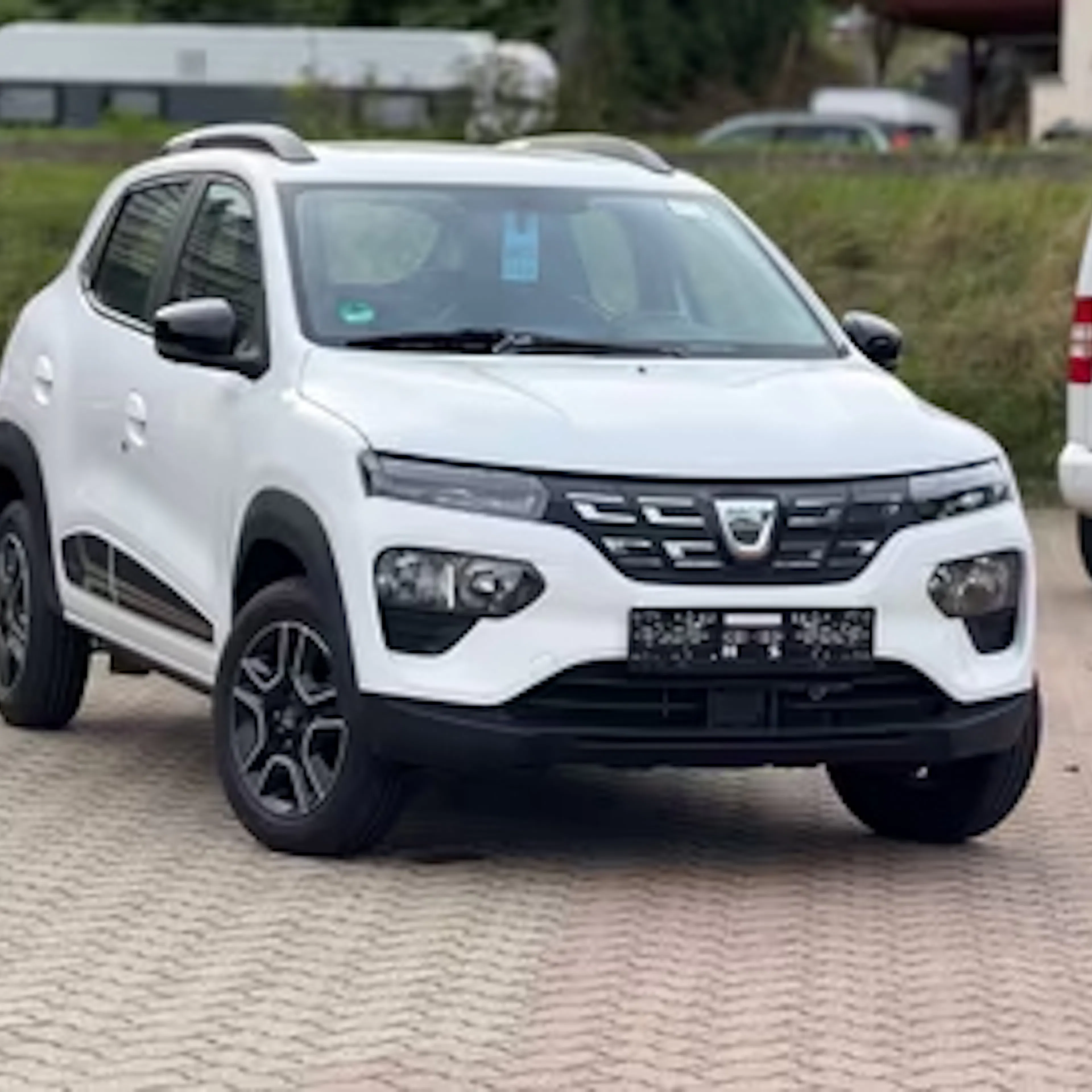 Weißer Dacia Spring auf einem Parkplatz
