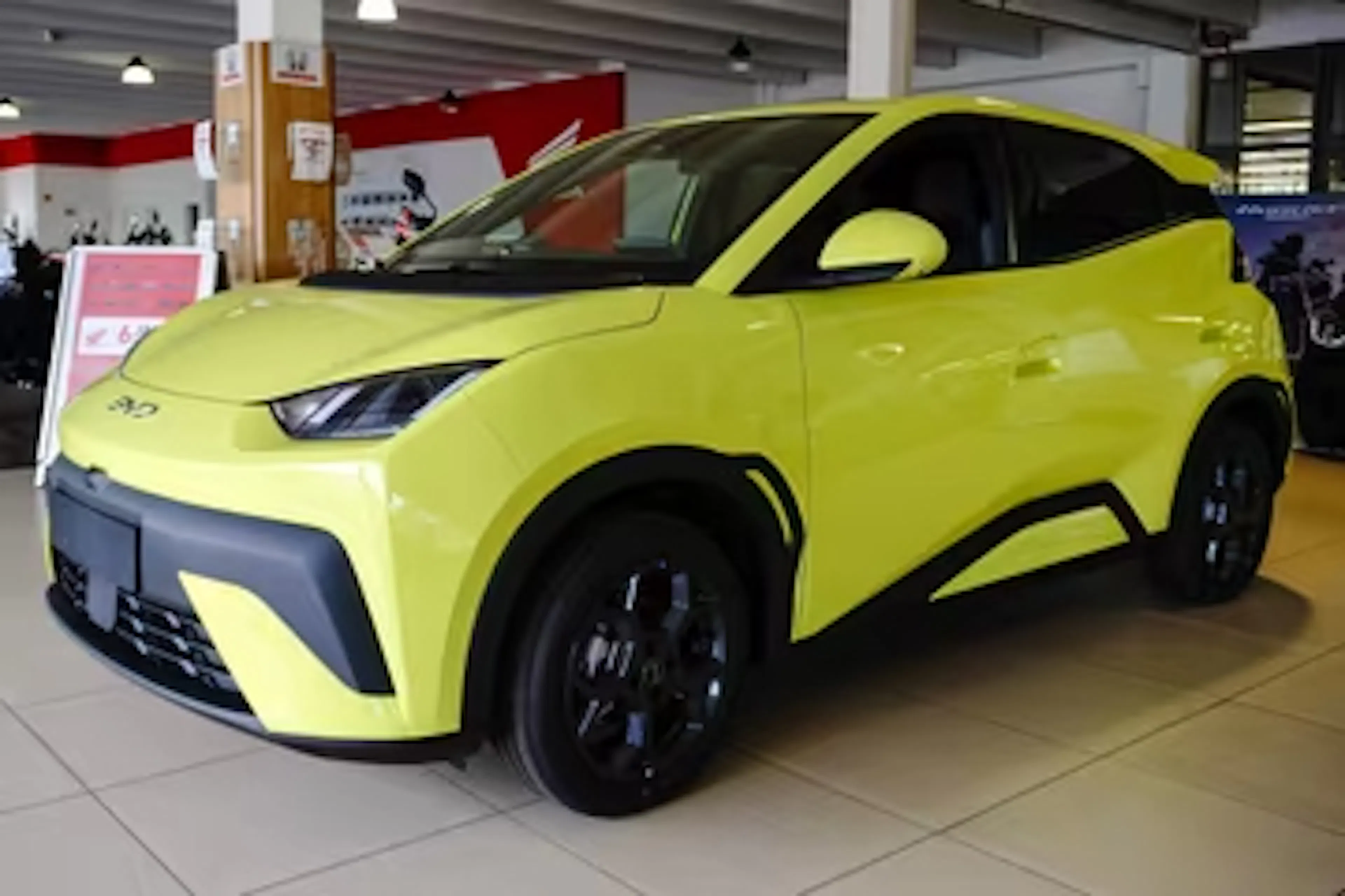 Ein gelber BYD Dolphin Surf steht in einem Autohaus.