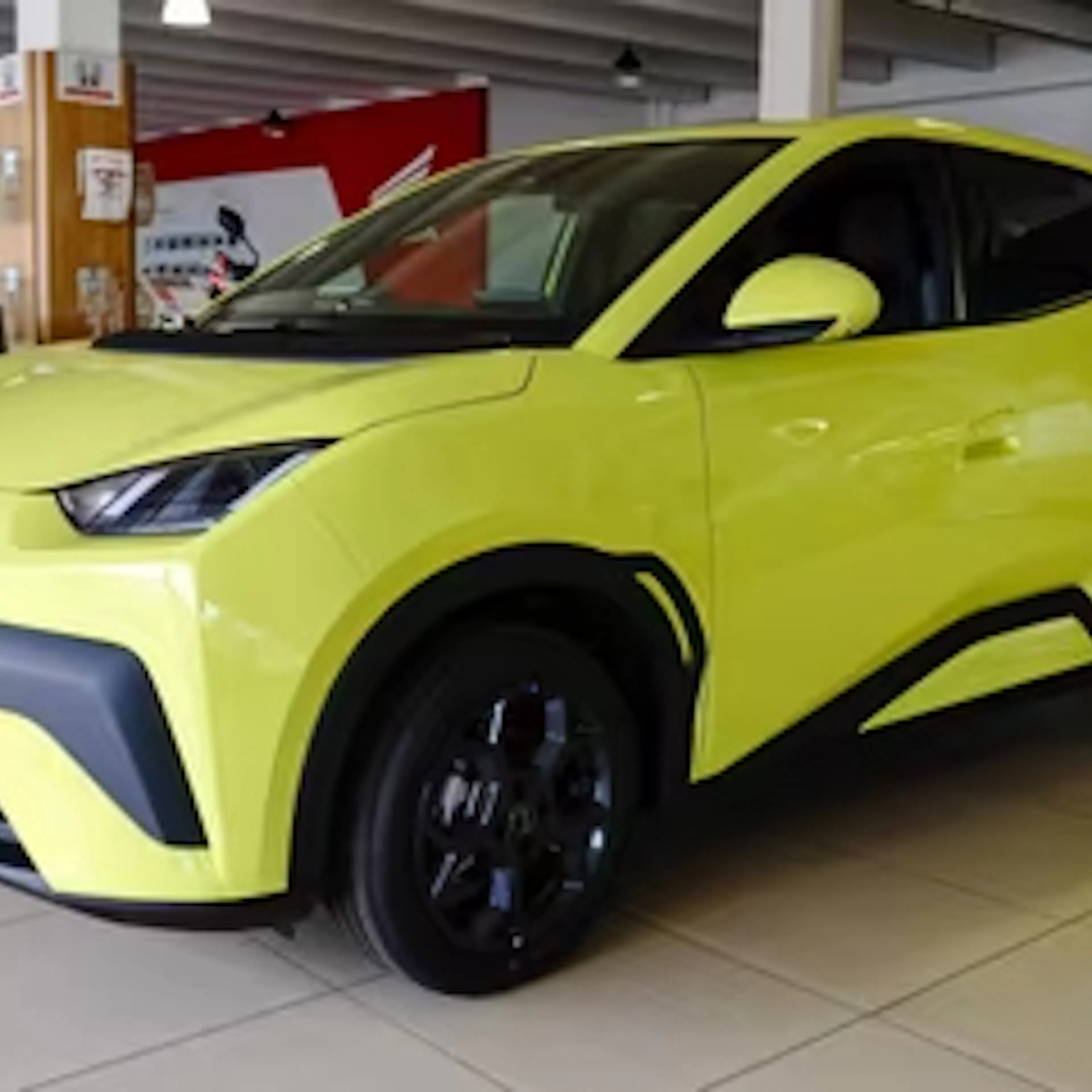 Ein gelber BYD Dolphin Surf steht in einem Autohaus.