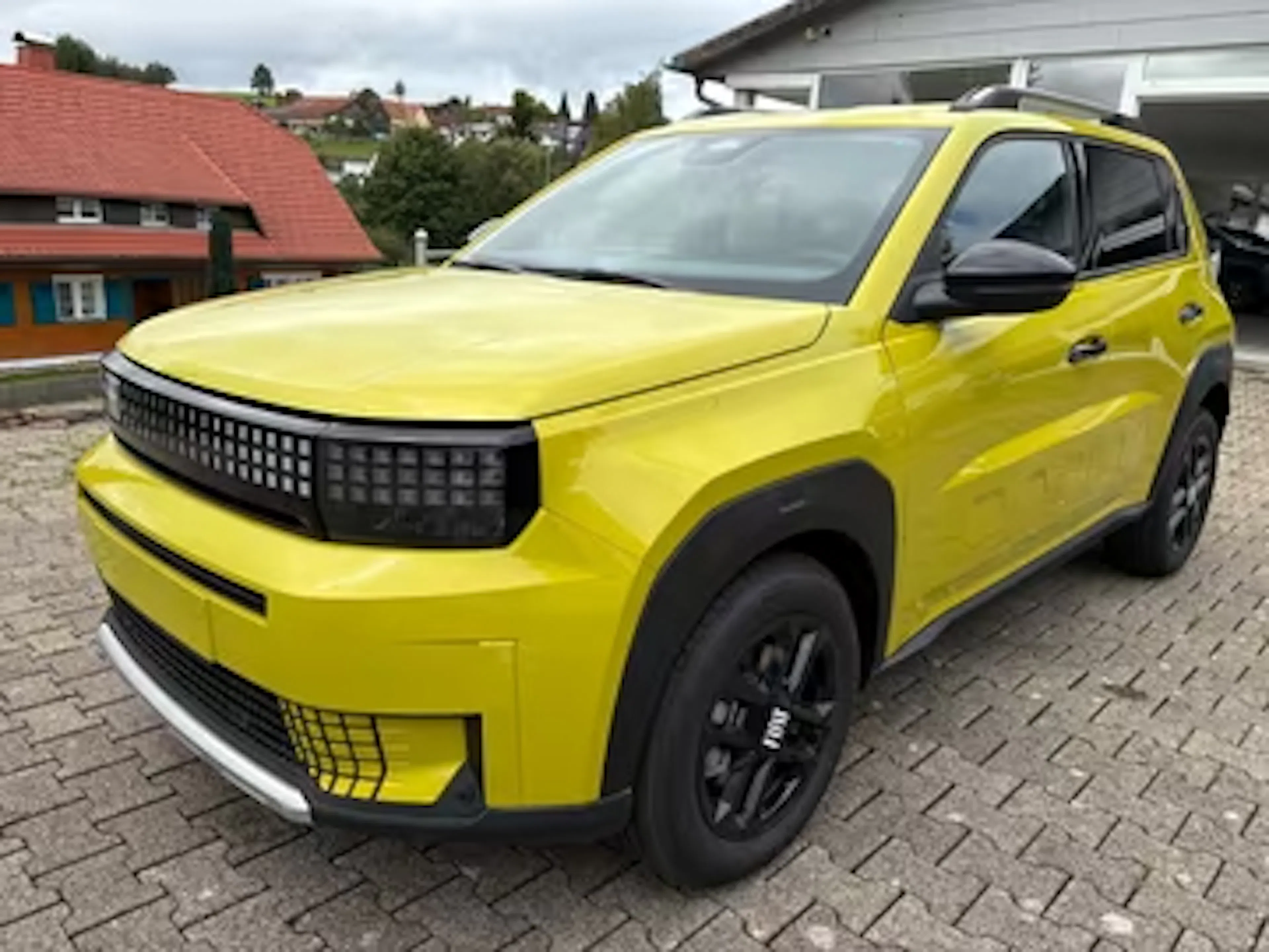 Ein gelber Fiat Panda Grande steht auf einem Parkplatz.