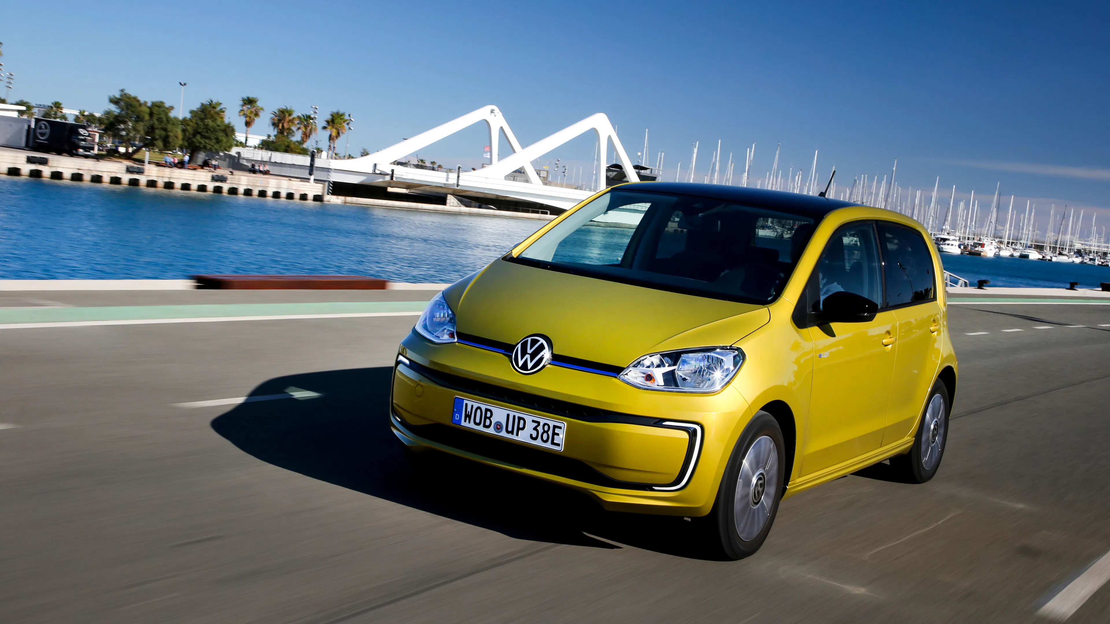Ein gelber VW e-up! fährt auf einer Straße.