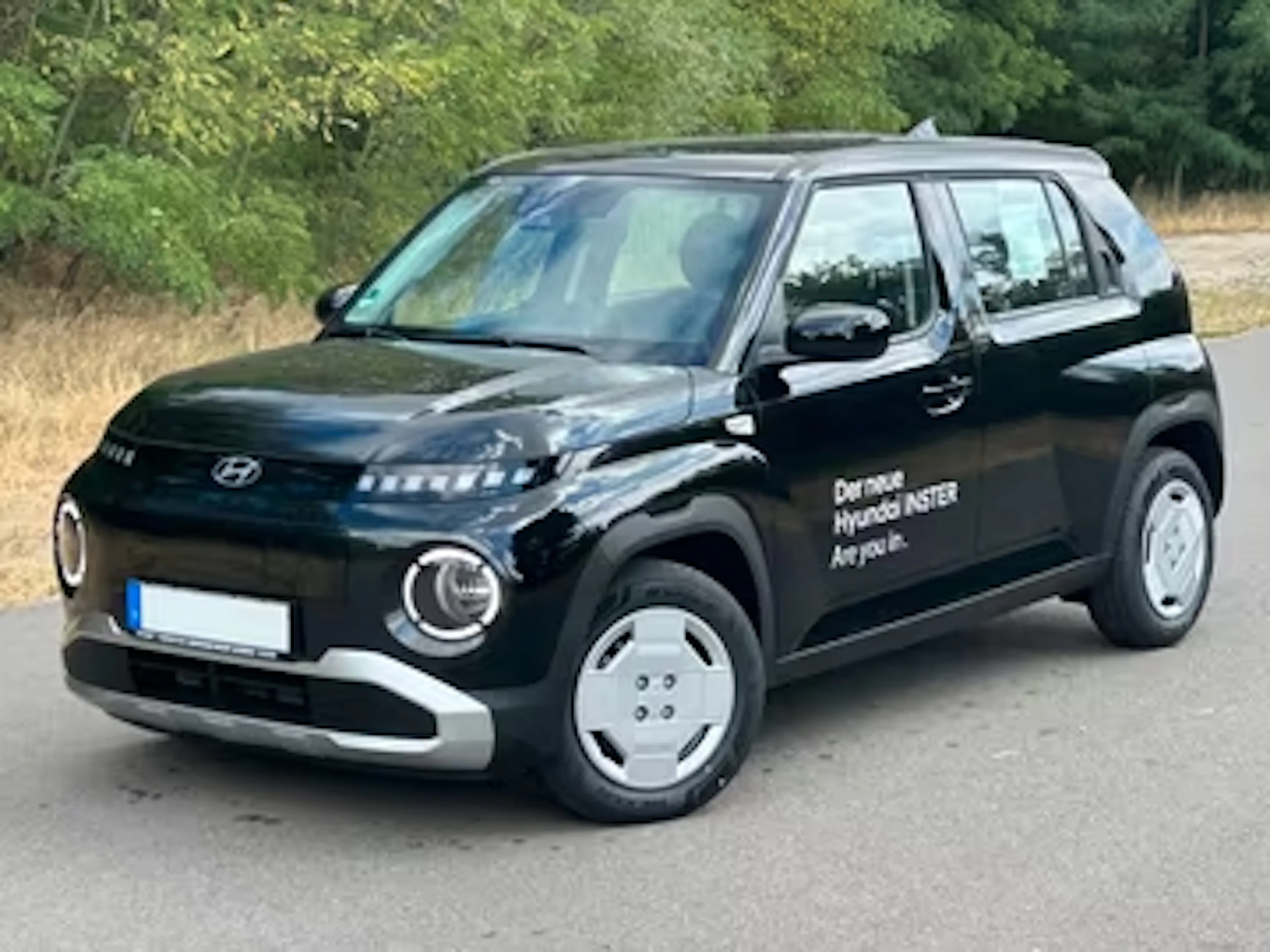 Ein schwarzer Hyundai Inster steht auf einer Straße.