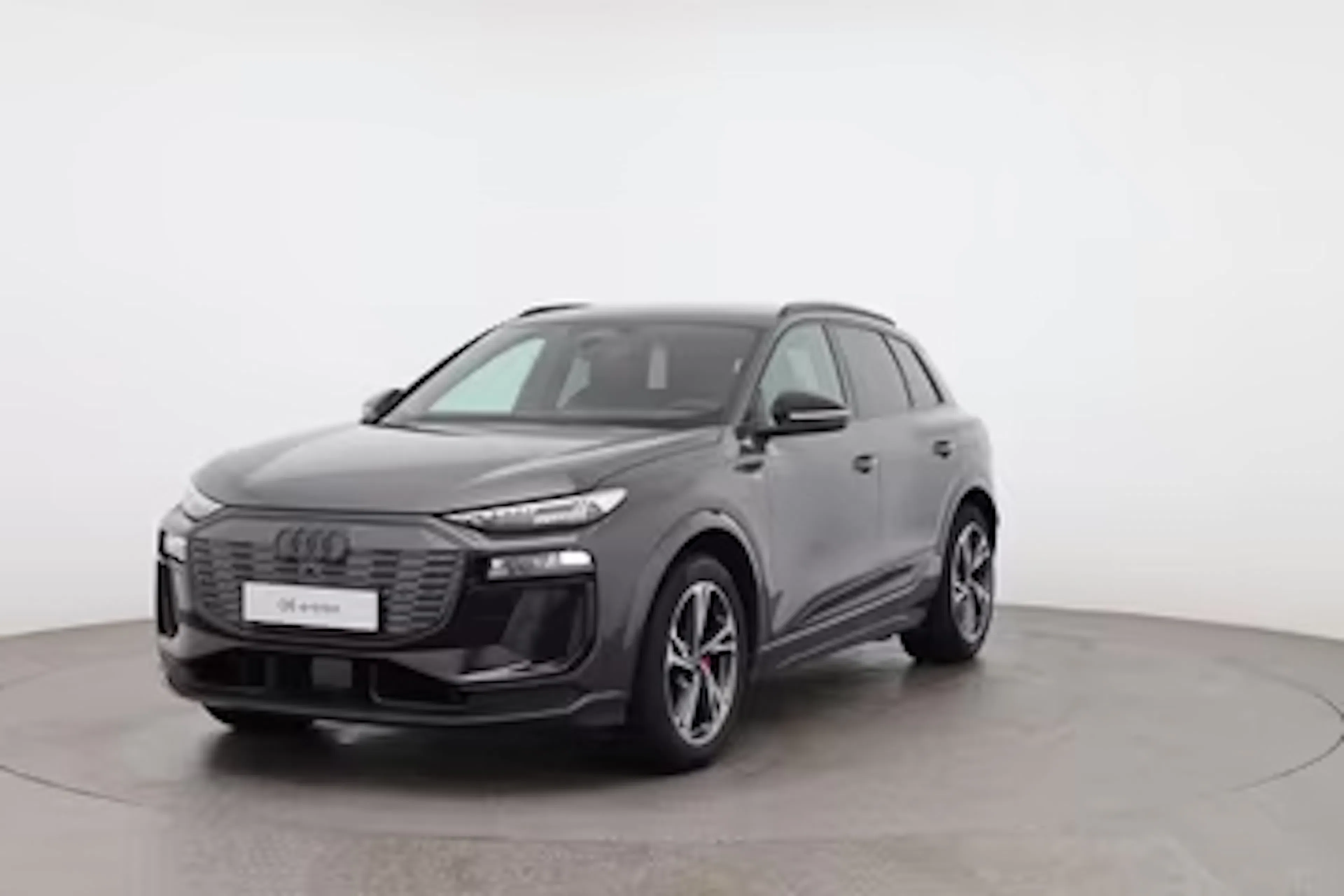 Schwarzer Audi SQ6 e-tron vor weißer Wand