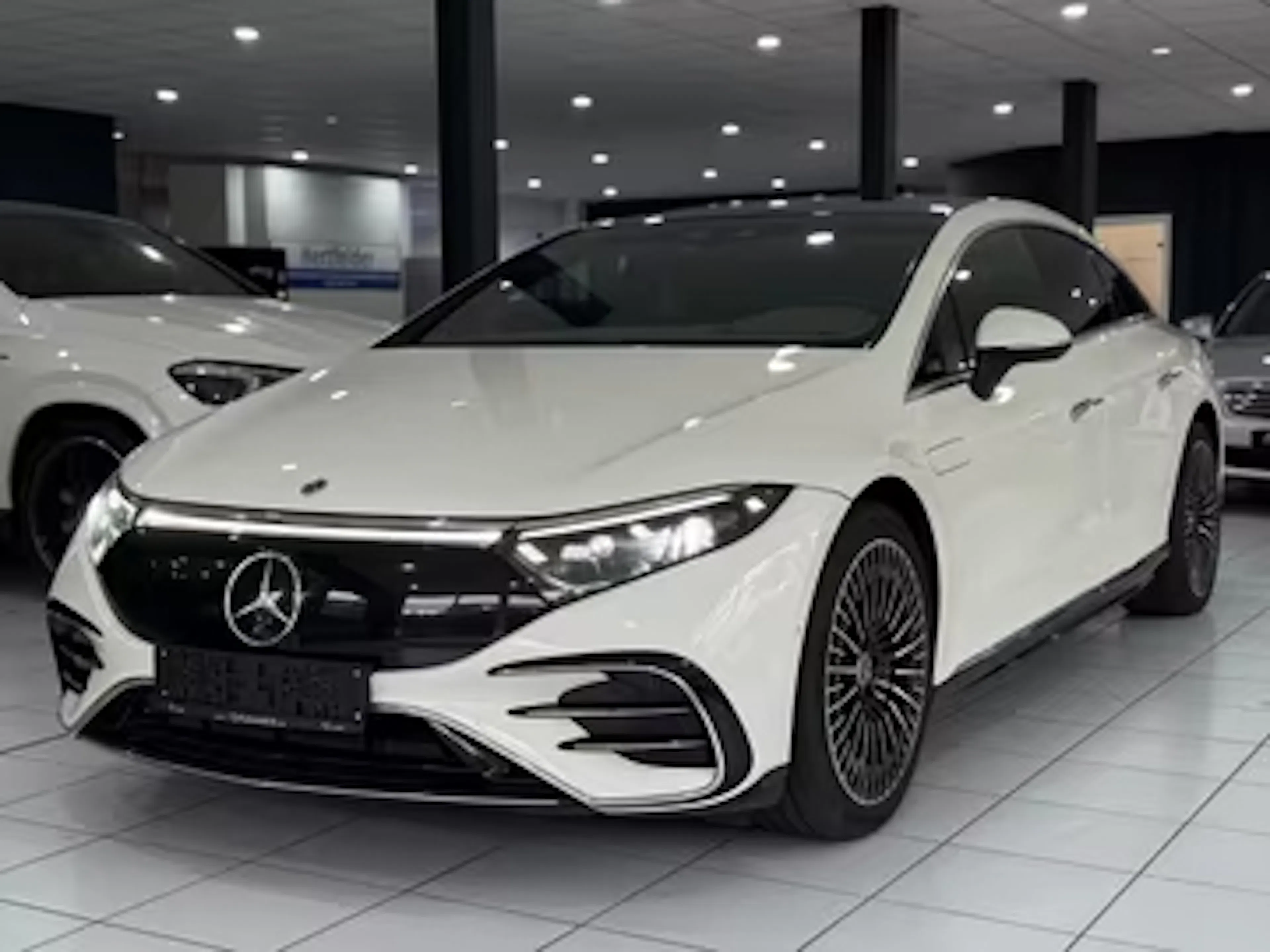 Weißer Mercedes EQS steht im Autohaus.