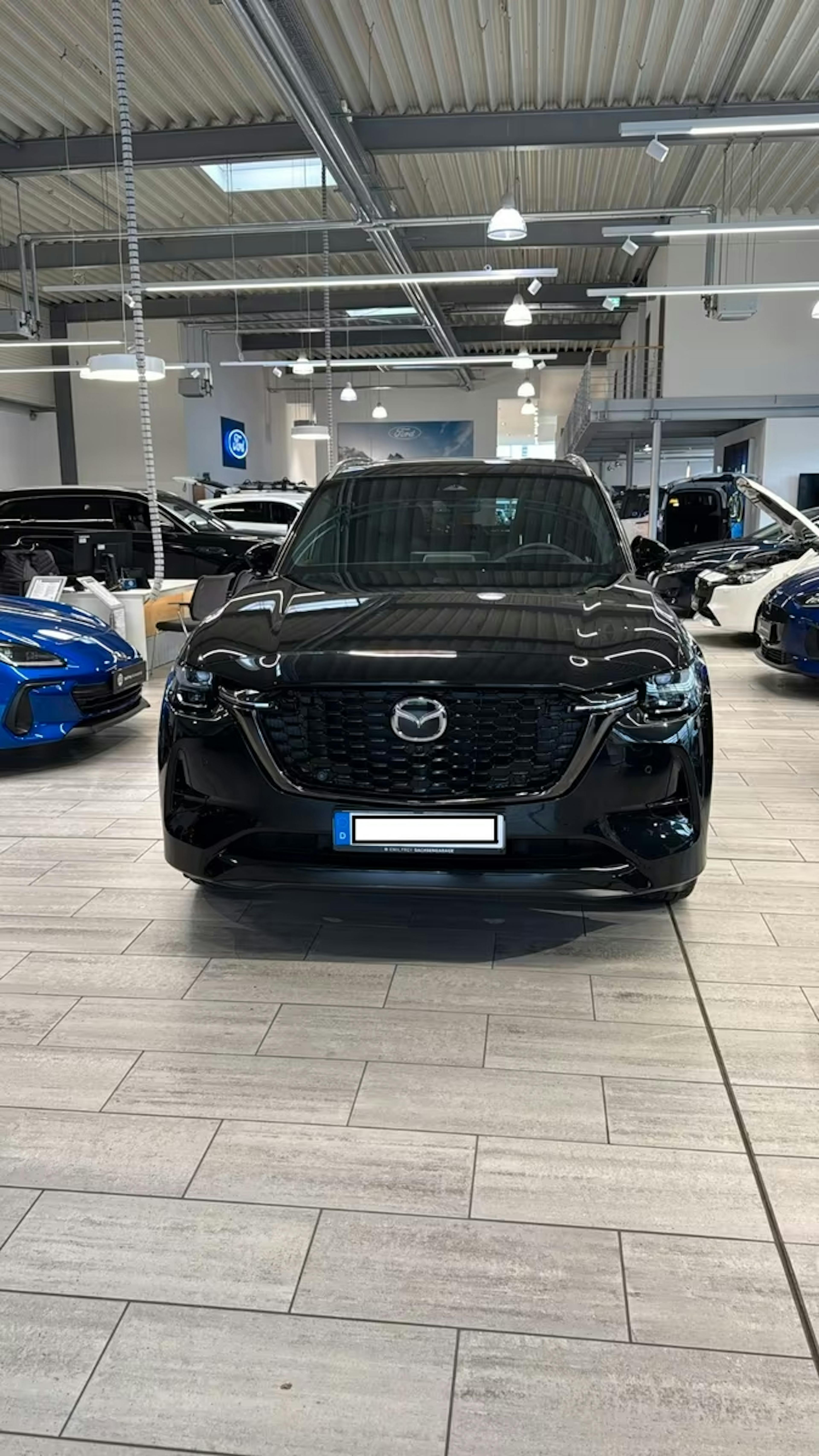 Ein schwarzer Mazda CX-80 steht in einem Autohaus.
