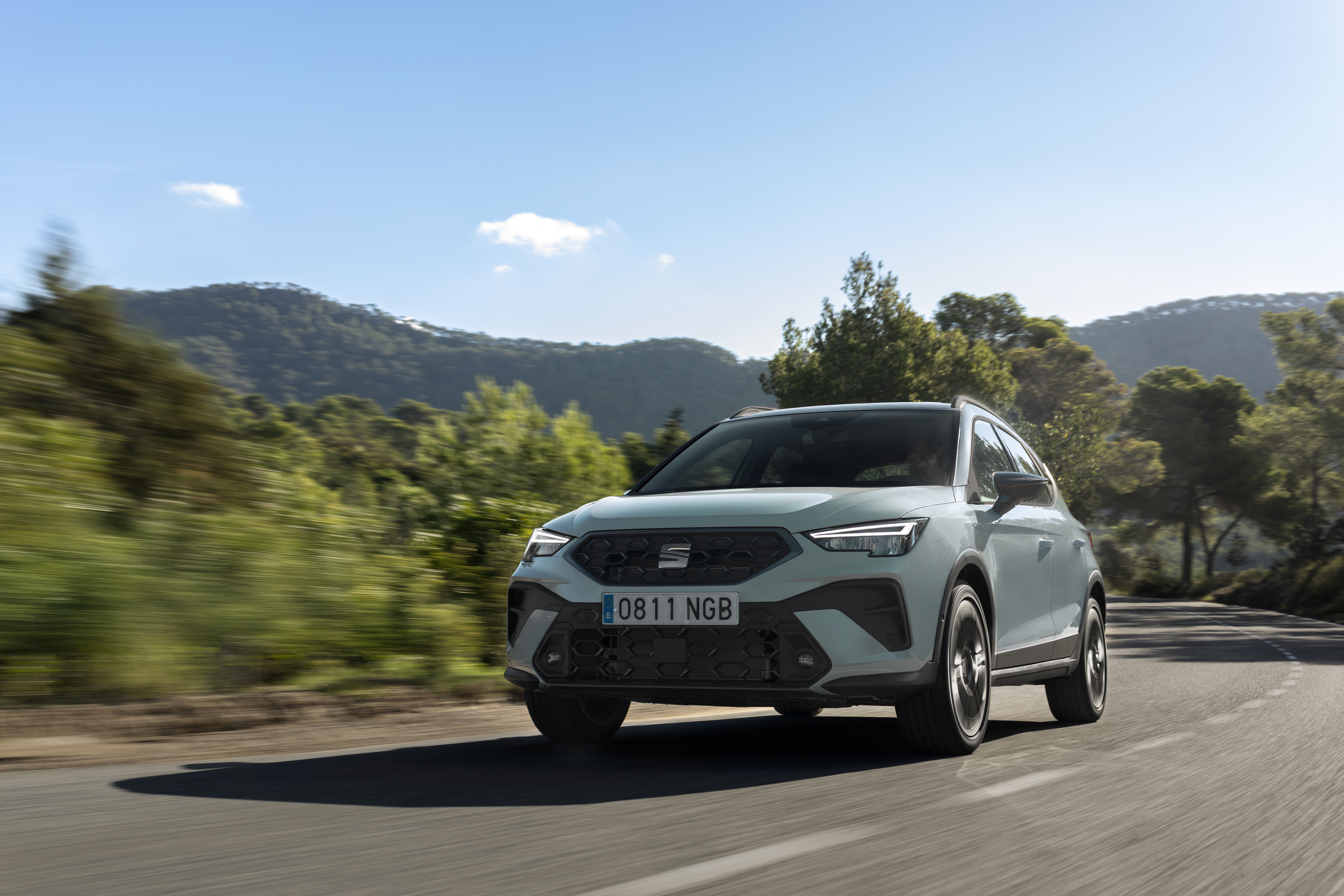 Ein neuer Seat Arona fährt eine szenische Straße entlang.