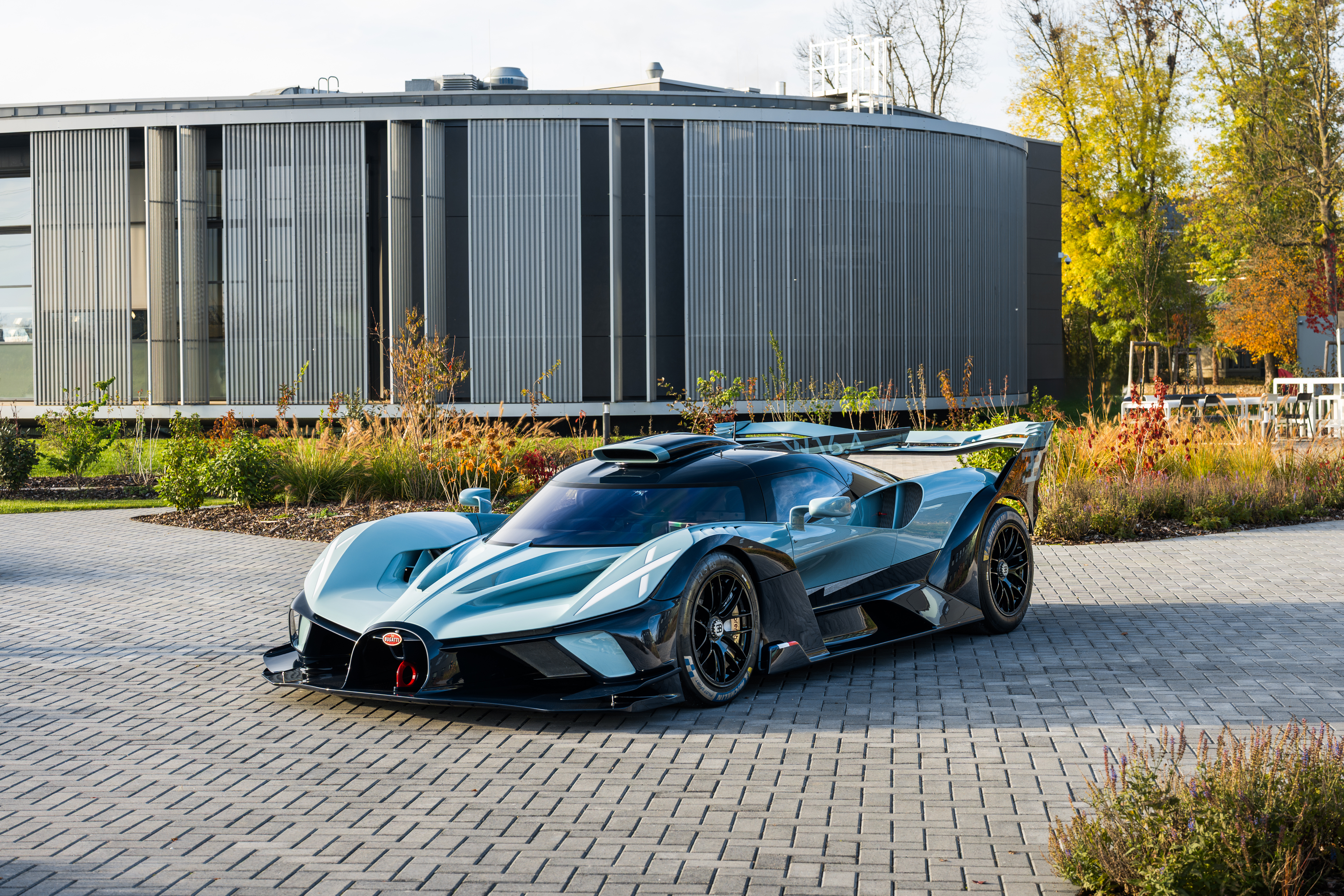 Ein Bugatti Bolide steht auf einer gepflasterten Fläche.