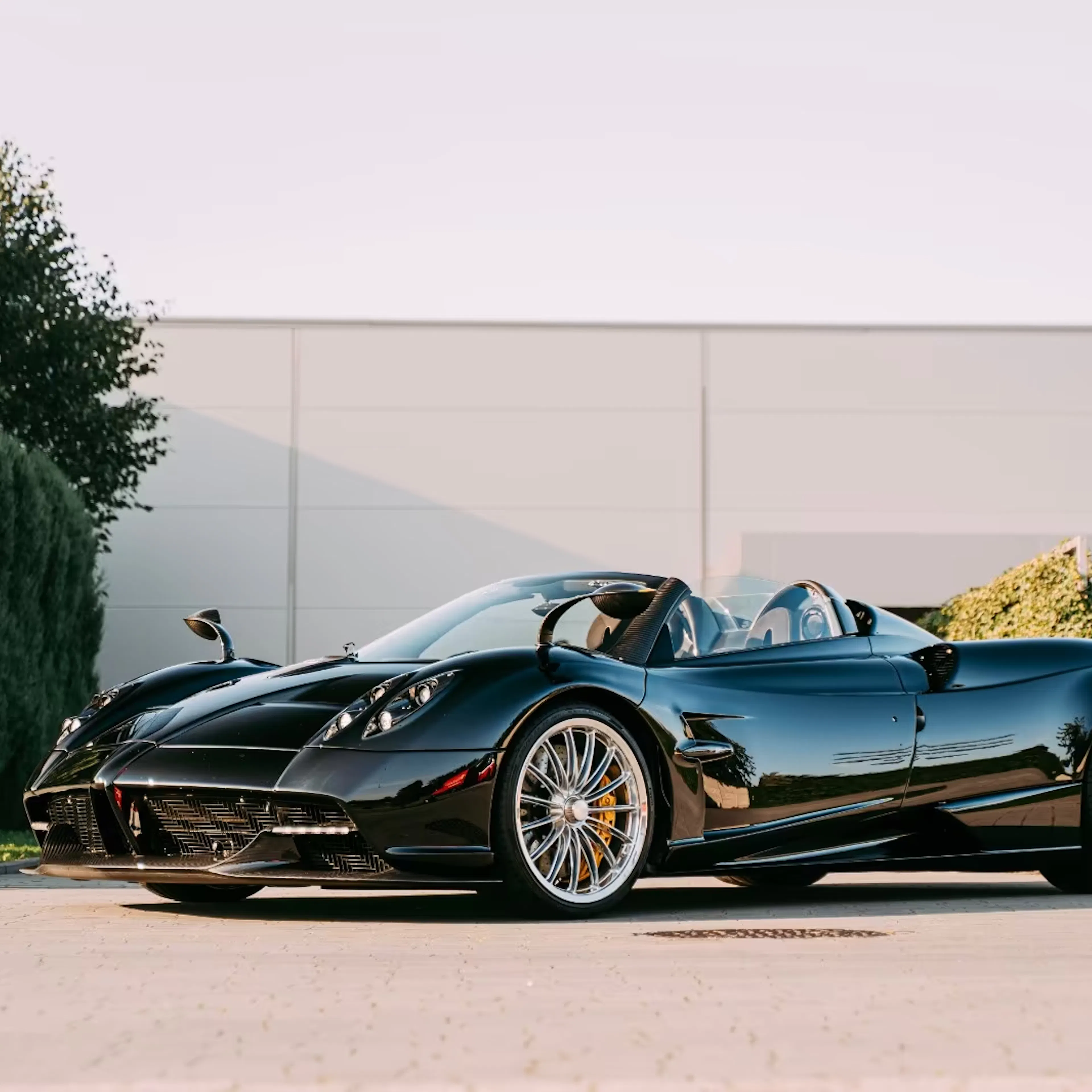Ein Pagani Huayra steht vor einer weißen Wand im Freien