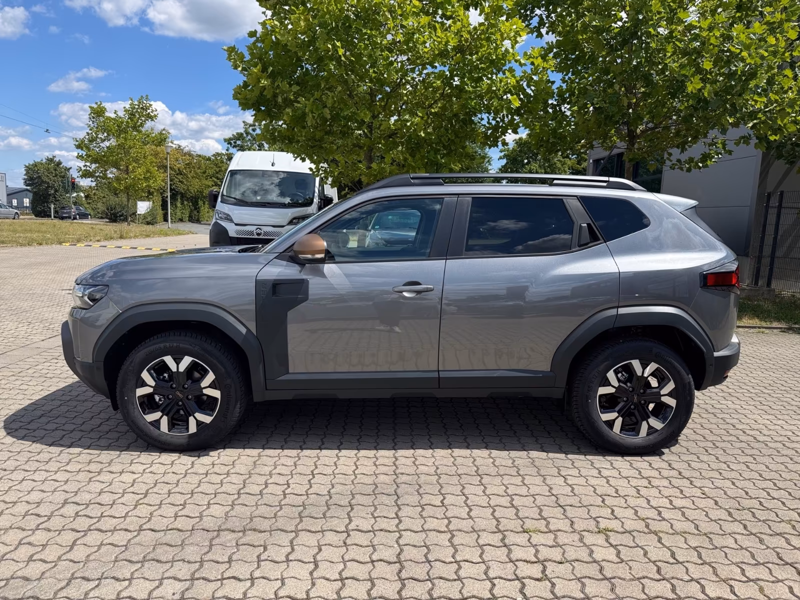 Ein silberner Dacia Duster steht auf einem Parkplatz