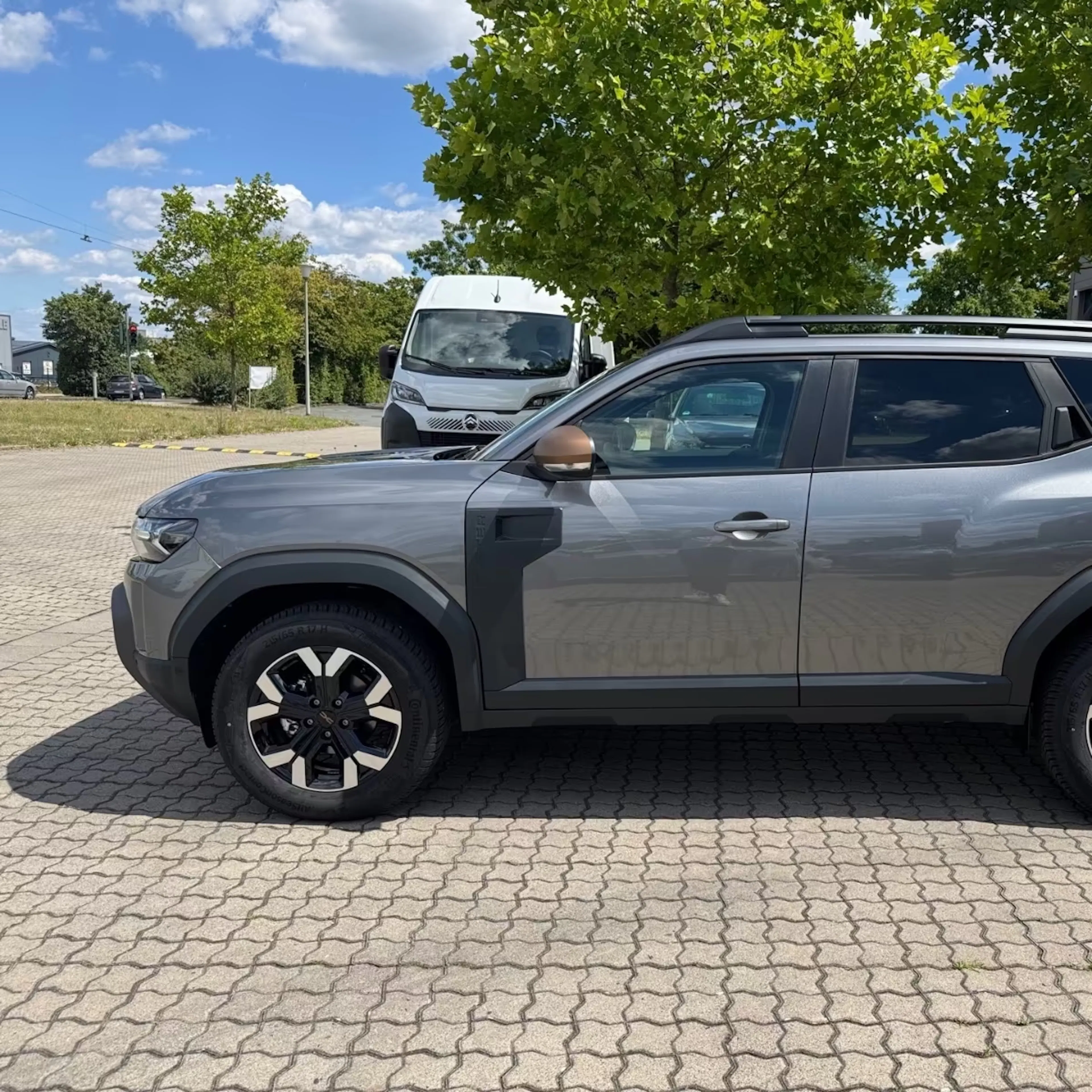 Ein silberner Dacia Duster steht auf einem Parkplatz