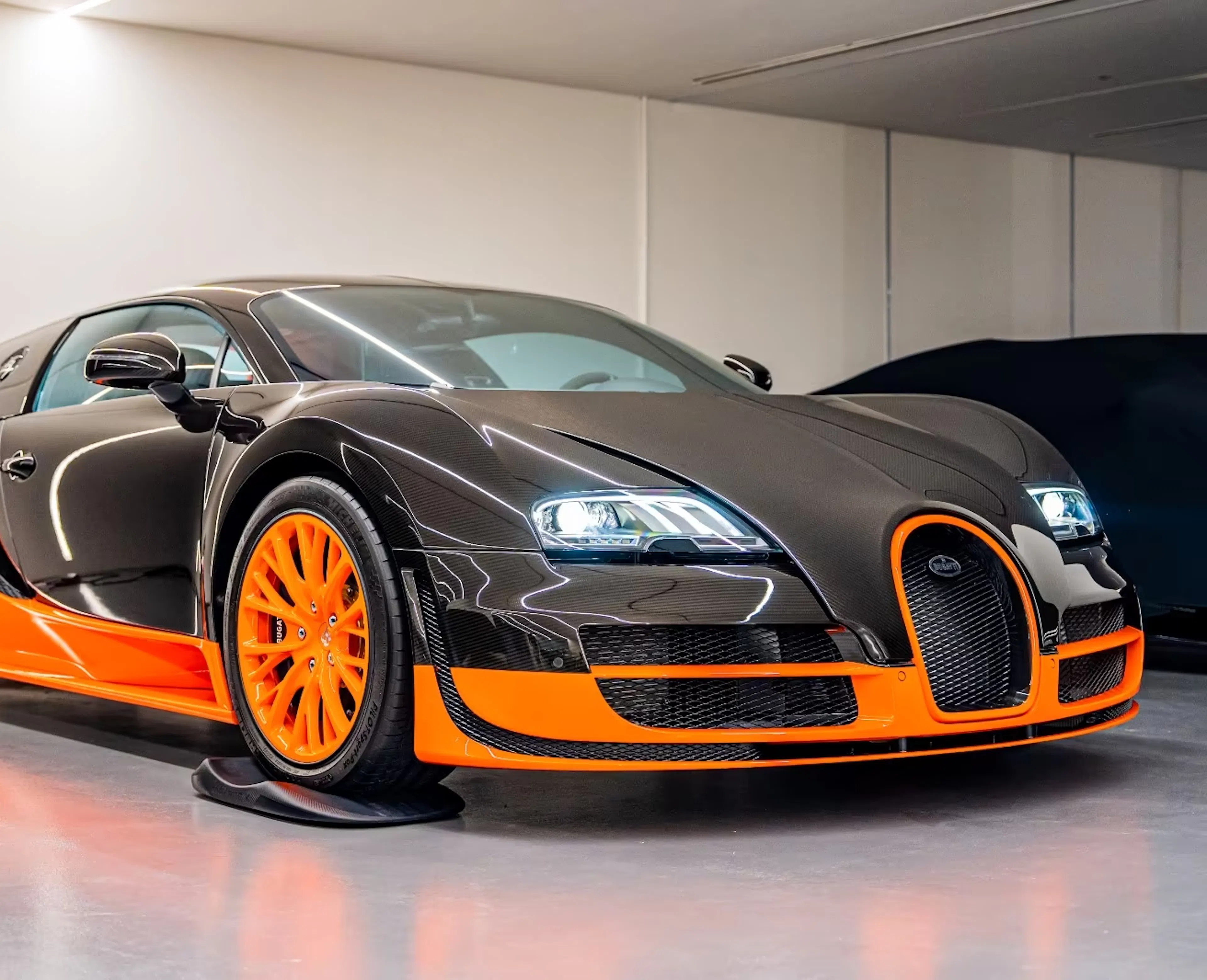 Ein schwarz-orangefarben lackierter Bugatti Veyron Super Sport