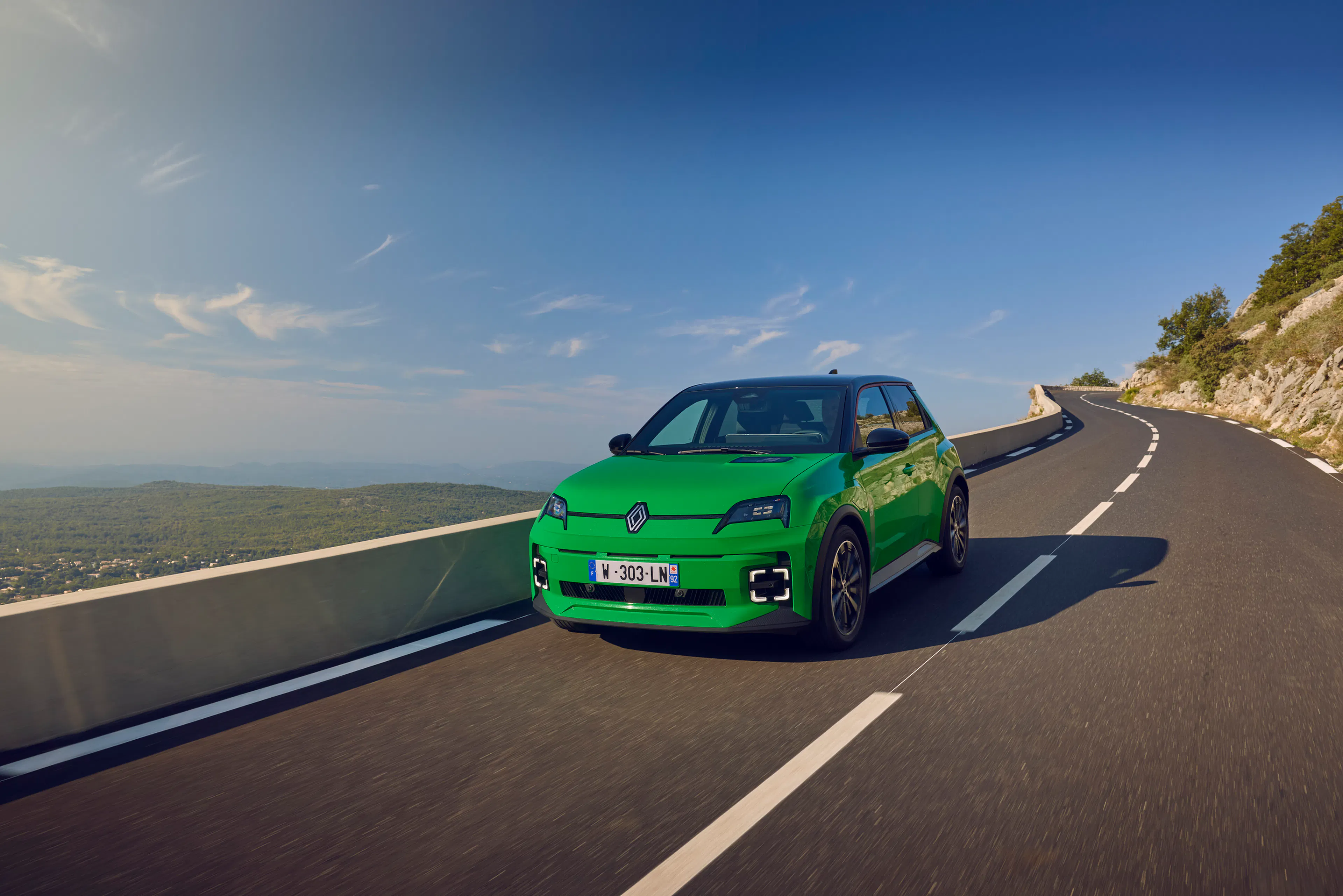 Ein grüner Renault 5 E-Tech Electric an einer Küstenstraße
