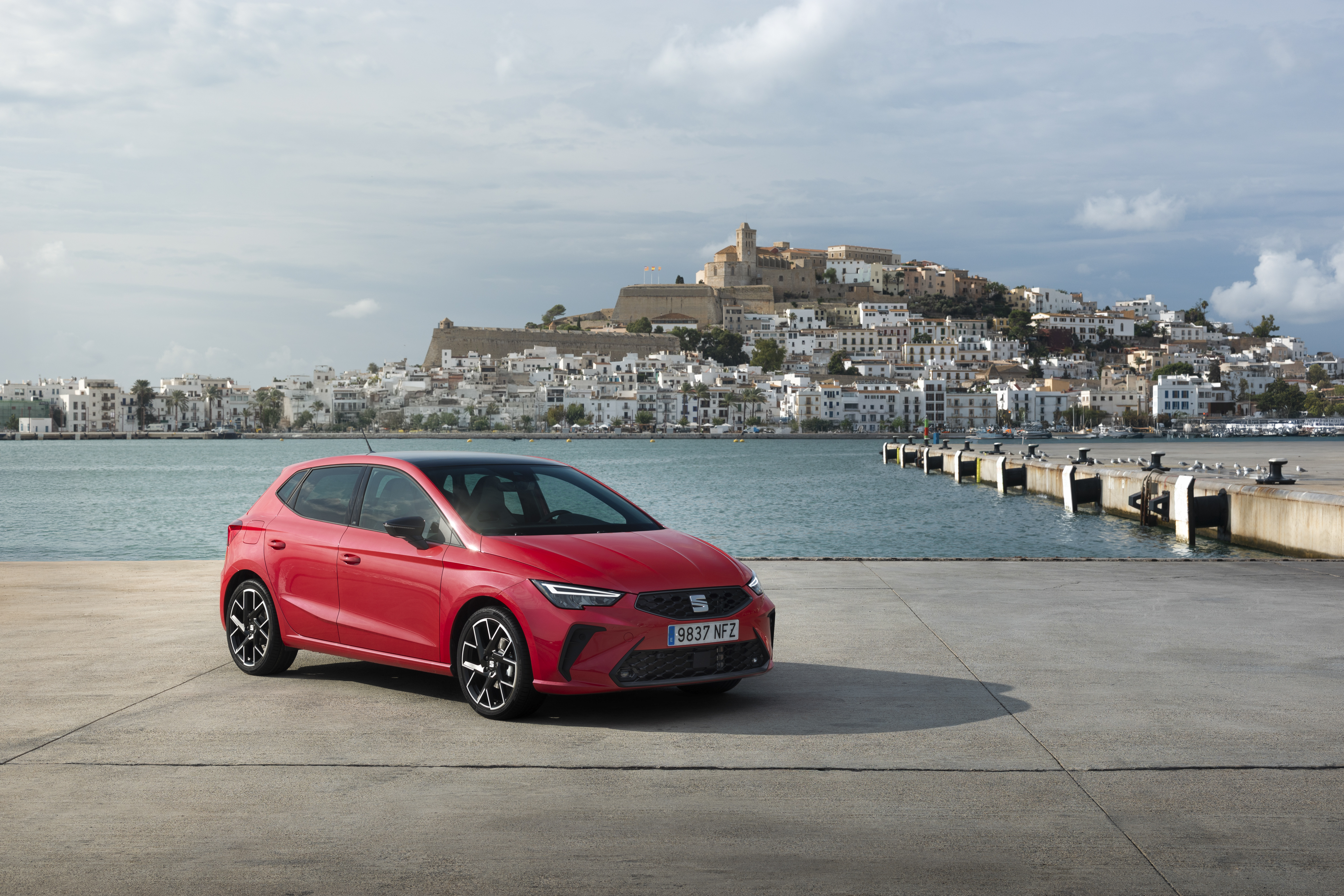 Ein roter Seat Ibiza steht auf einer betonierten Fläche am Hafen