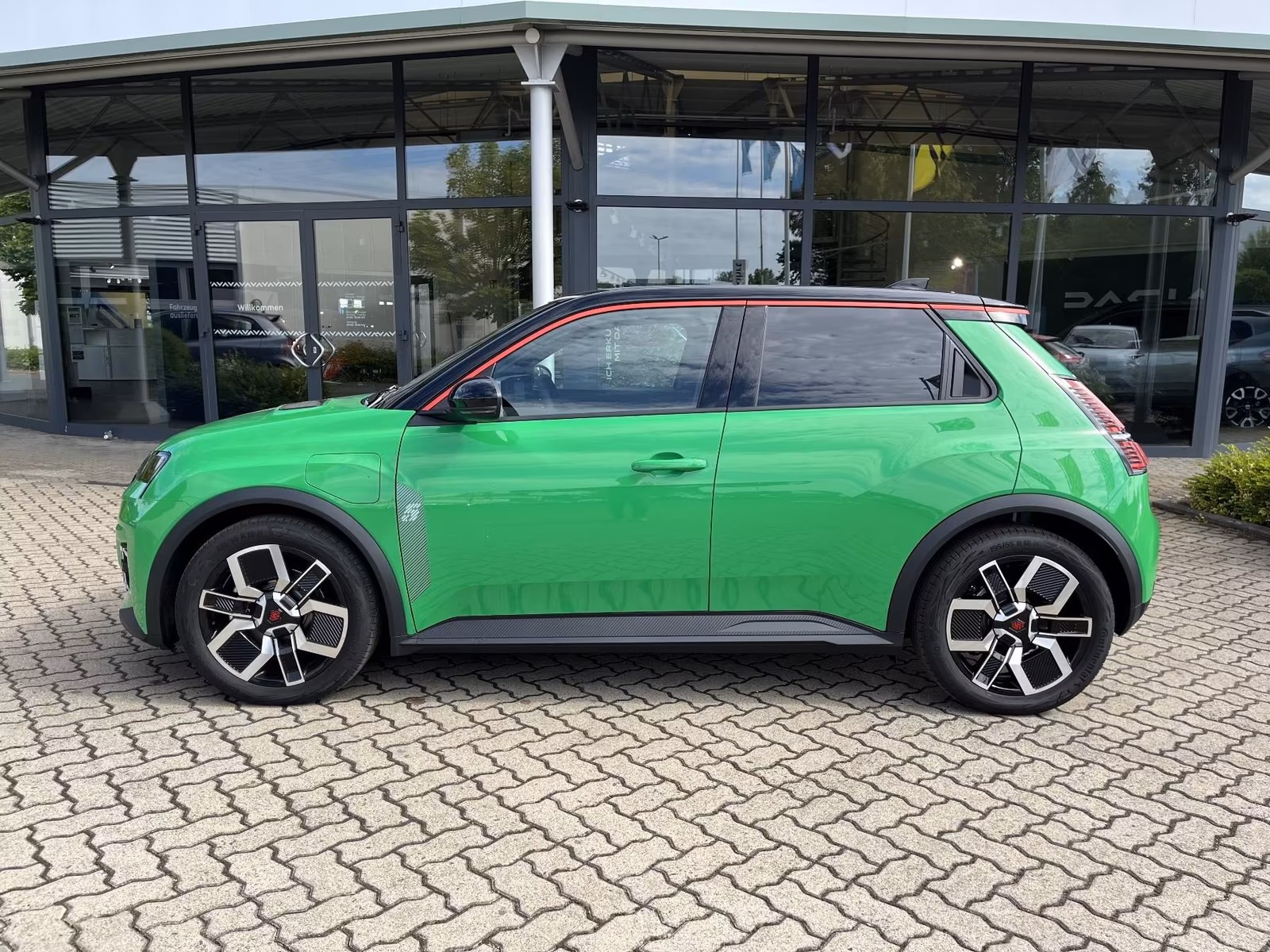 Ein grüner Renault 5 auf einer gepflasterten Fläche
