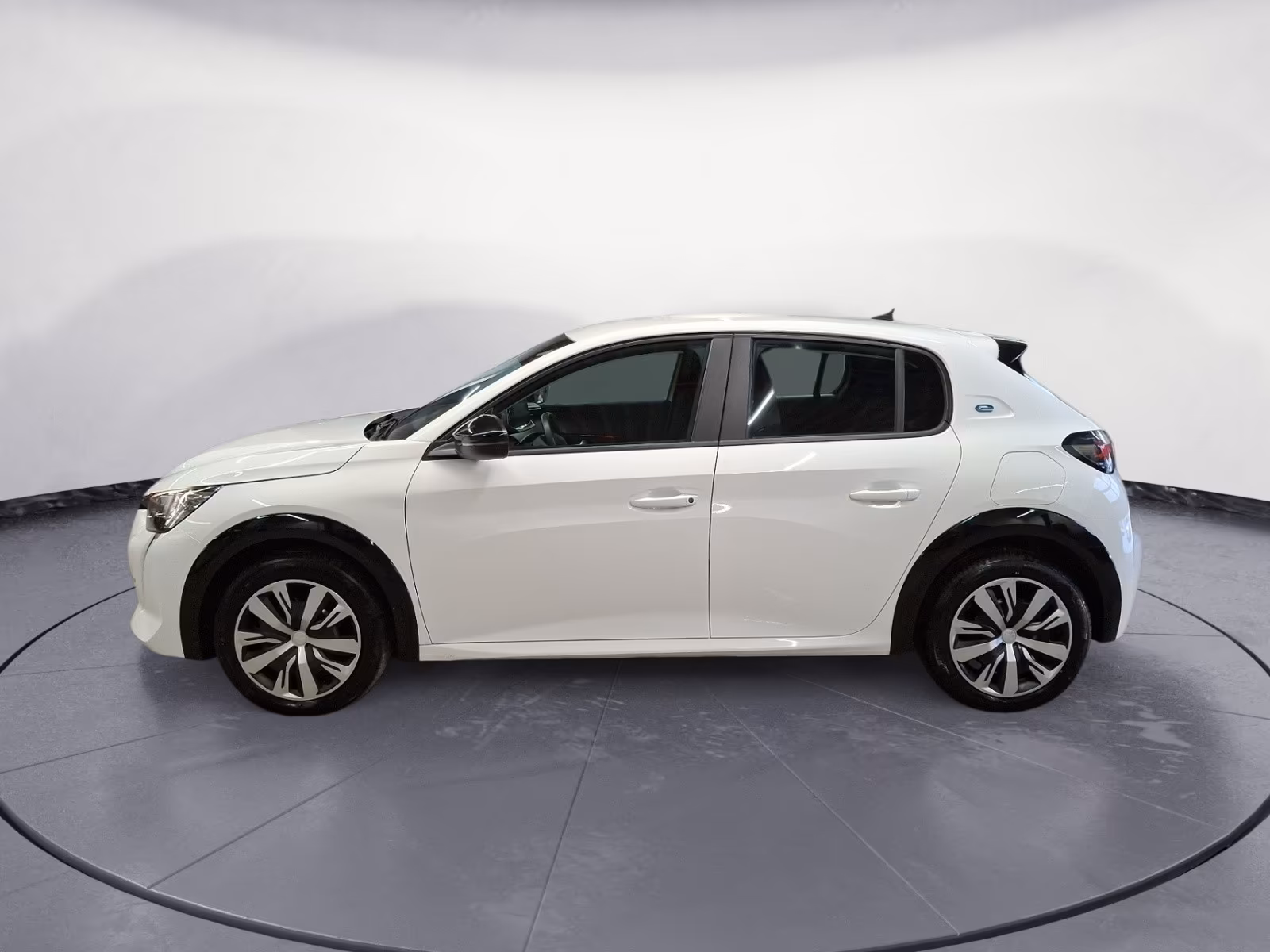 Ein weißer Peugeot e-208 steht auf einer Präsentationsfläche