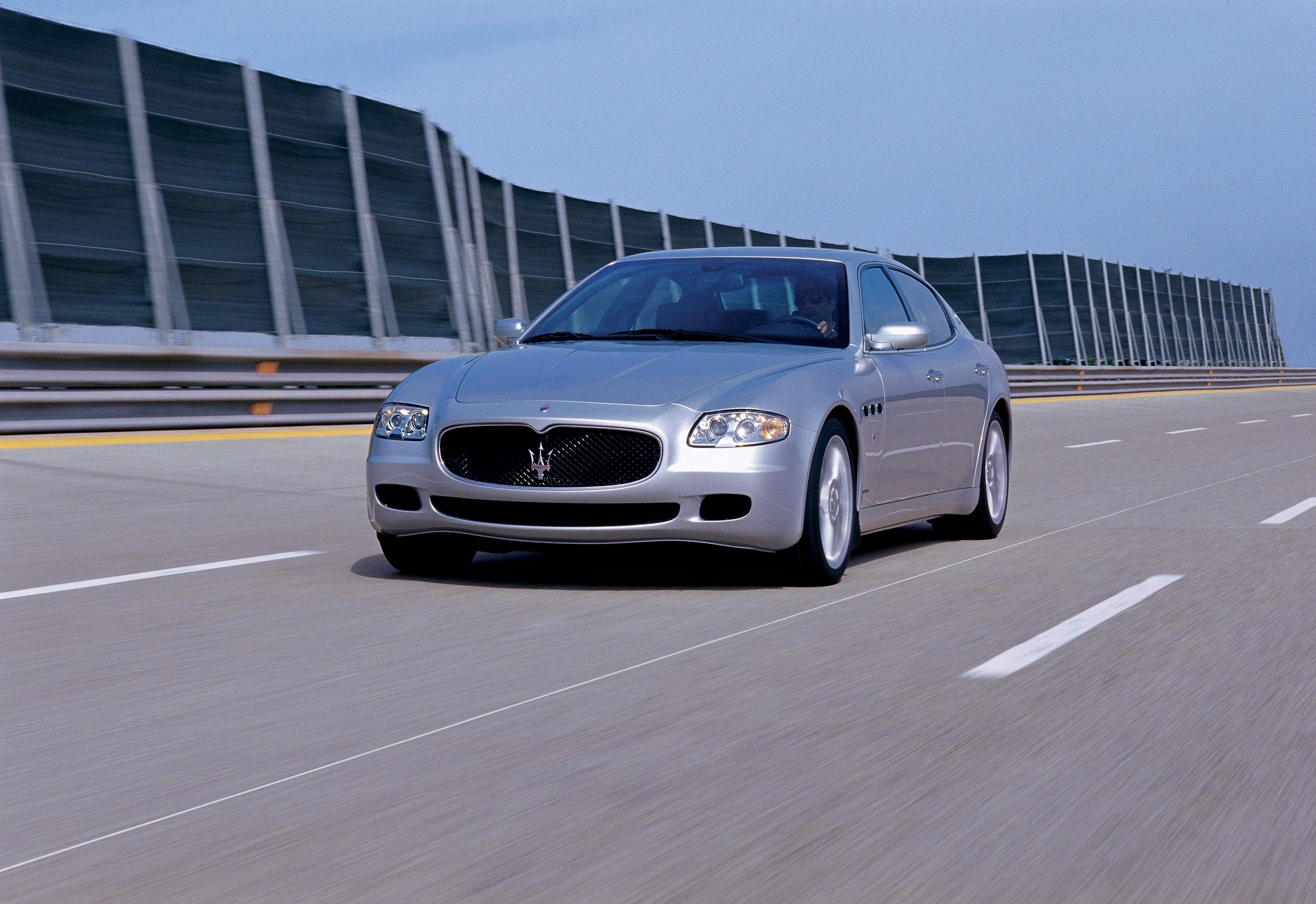 Ein silberner Maserati Quattroporte V fährt auf einer Autobahn.