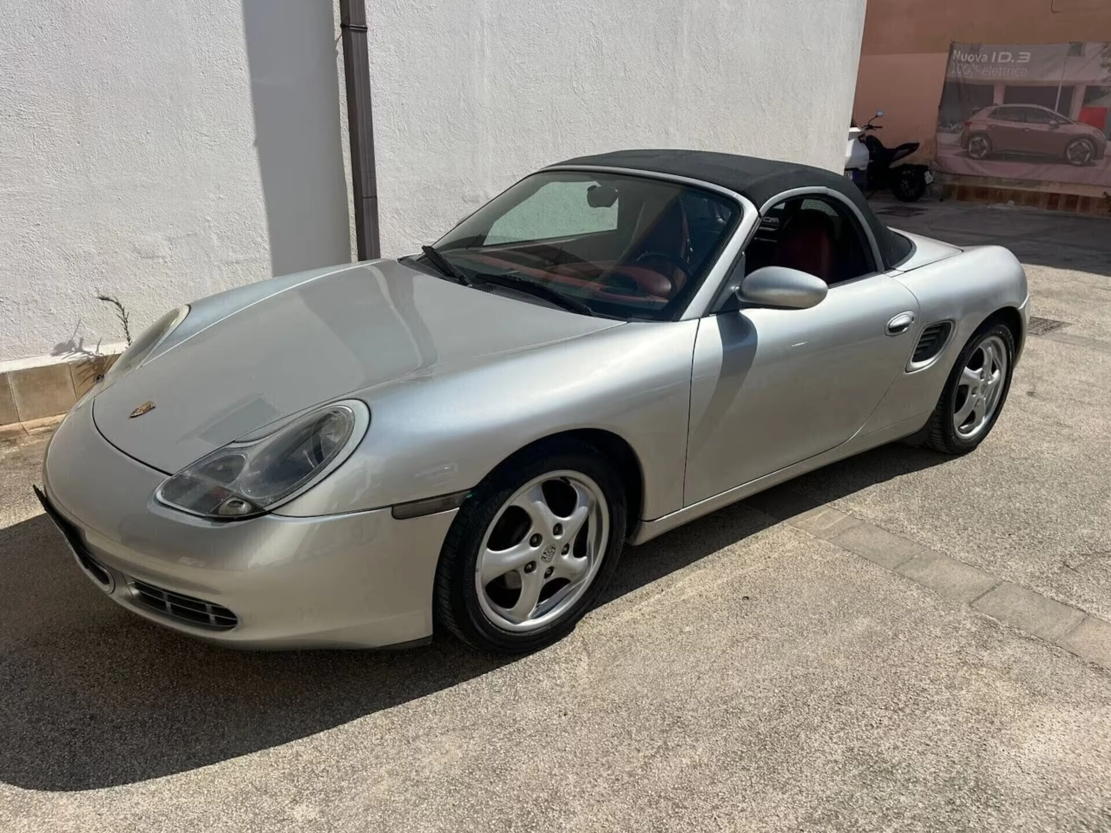 Ein silberner Porsche Boxszer steht auf einem Parkplatz.