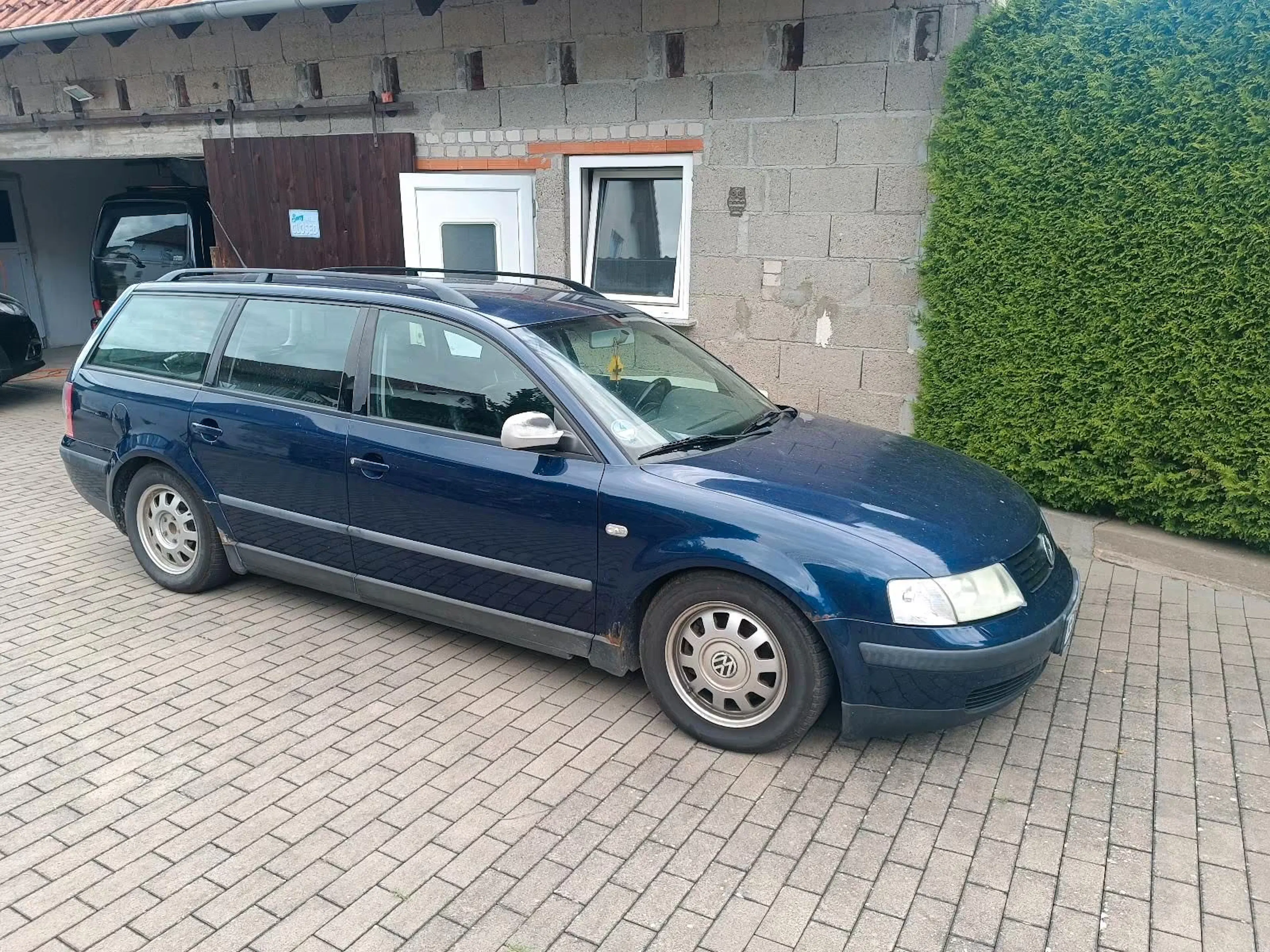 Ein dunkelblauer VW Passat Variant (B5) steht vor einem Haus.
