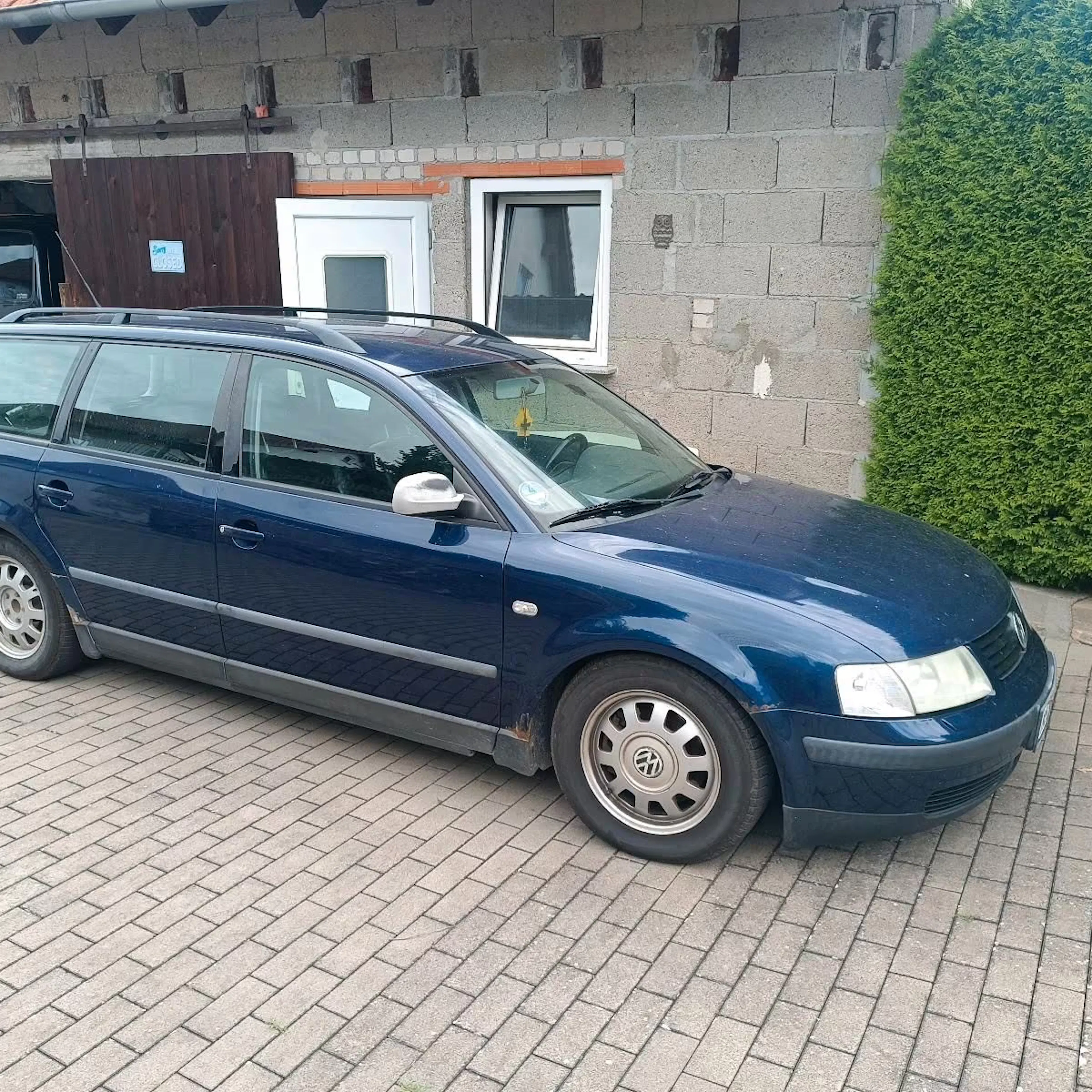 Ein dunkelblauer VW Passat Variant (B5) steht vor einem Haus.