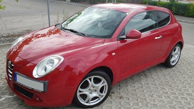Ein roter Alfa Romeo Mito steht in einer Einfahrt