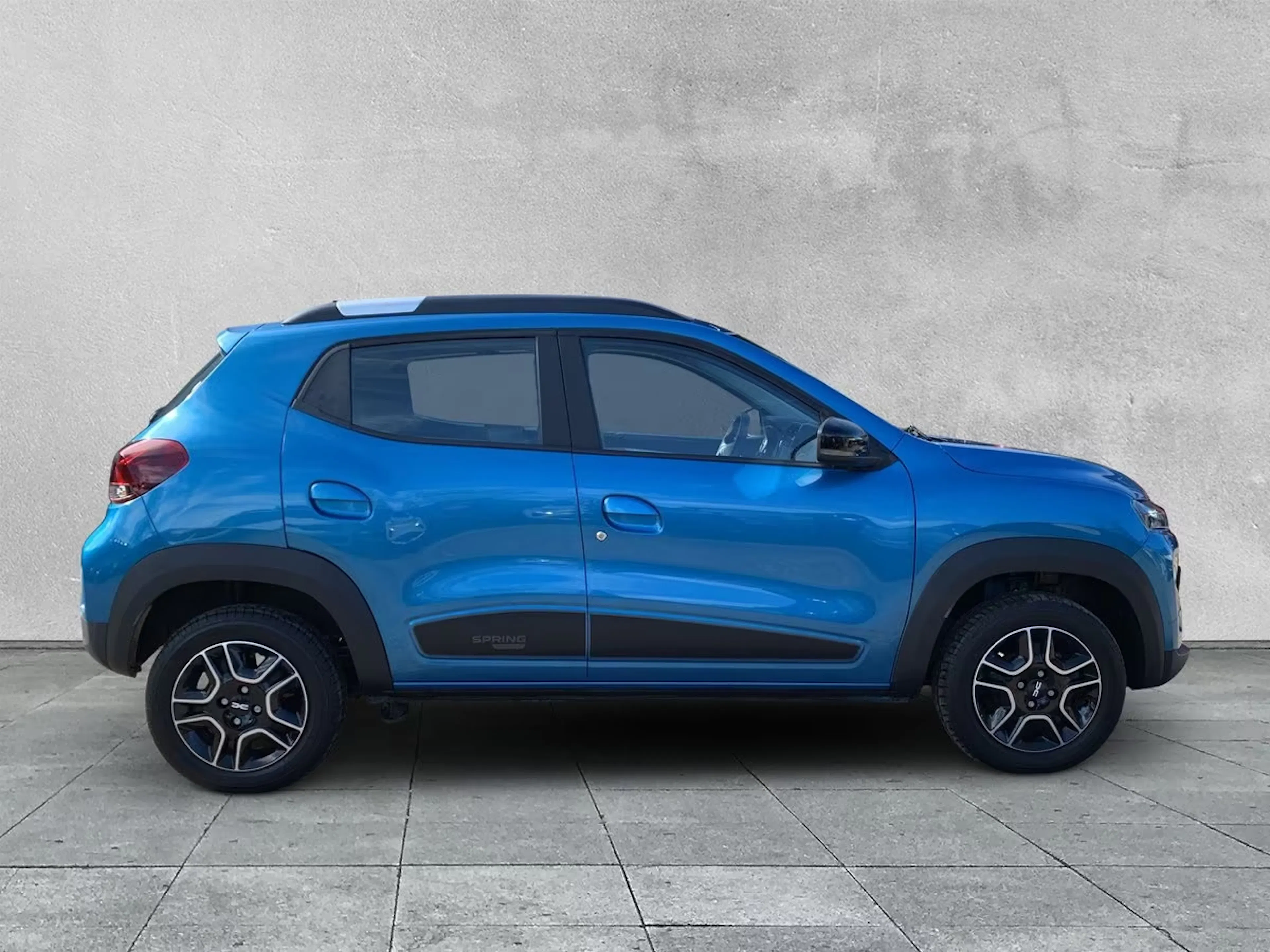 Ein blauer Dacia Spring steht auf der Verkaufsfläche zum Leasing bereit.