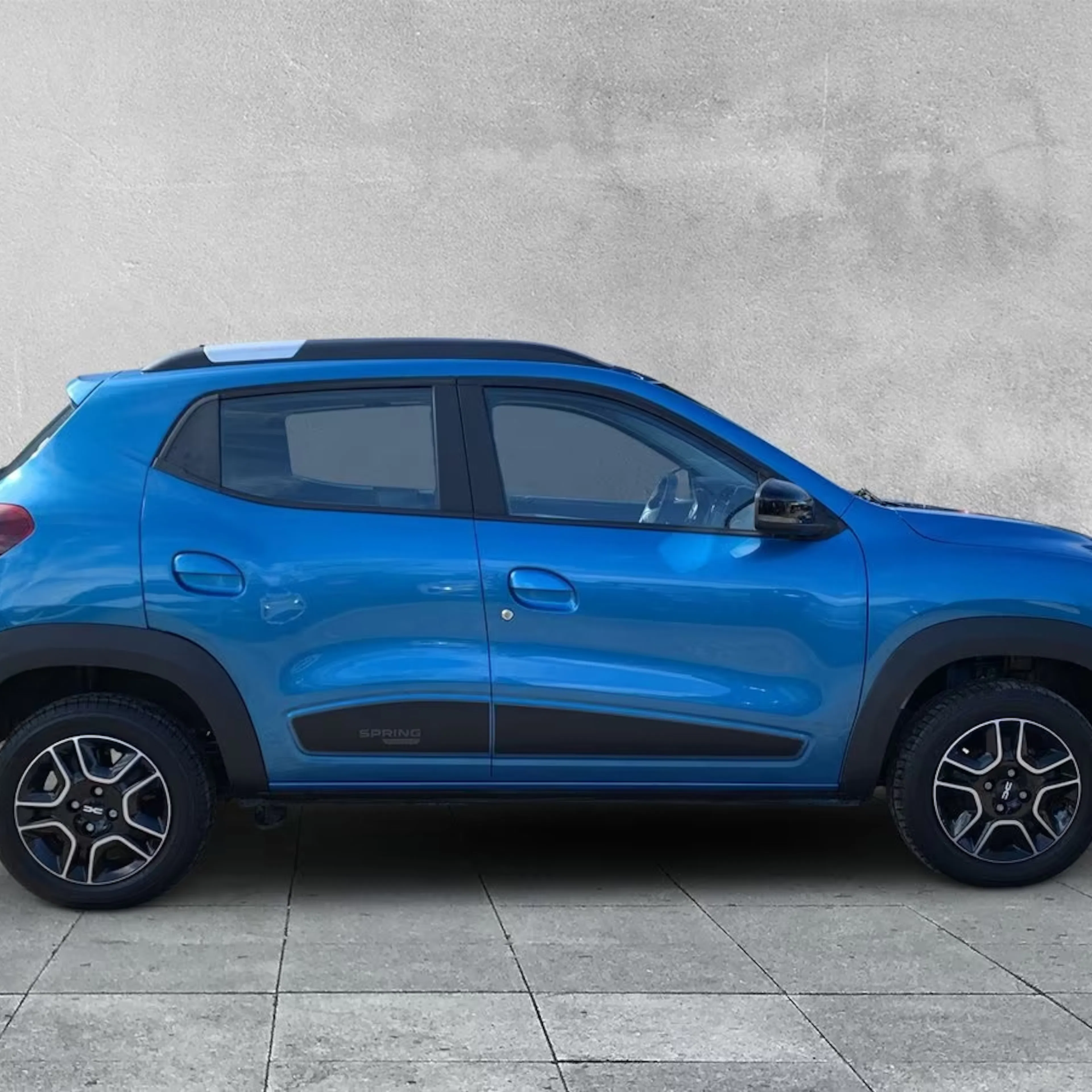 Ein blauer Dacia Spring steht auf der Verkaufsfläche zum Leasing bereit.