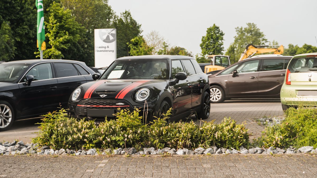 Ein Mini und andere Autos stehen auf einem Händlerparkplatz