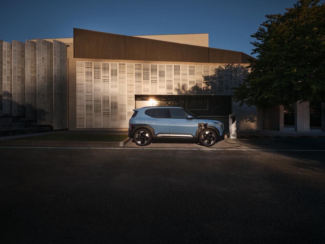 Kia EV2 vor einem grau-braunen Haus