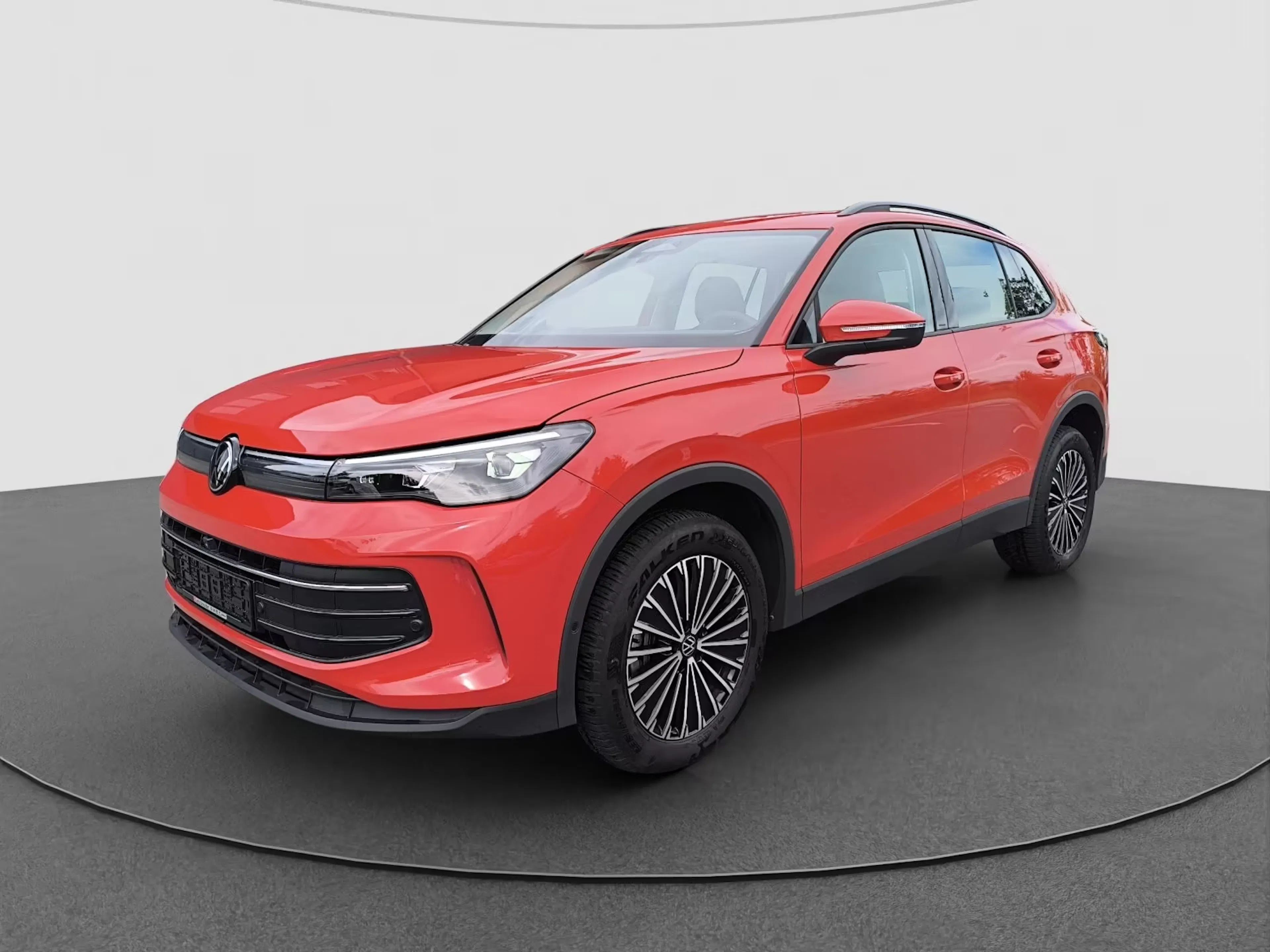 Ein roter Volkswagen Tiguan steht auf einer Verkaufsfläche.