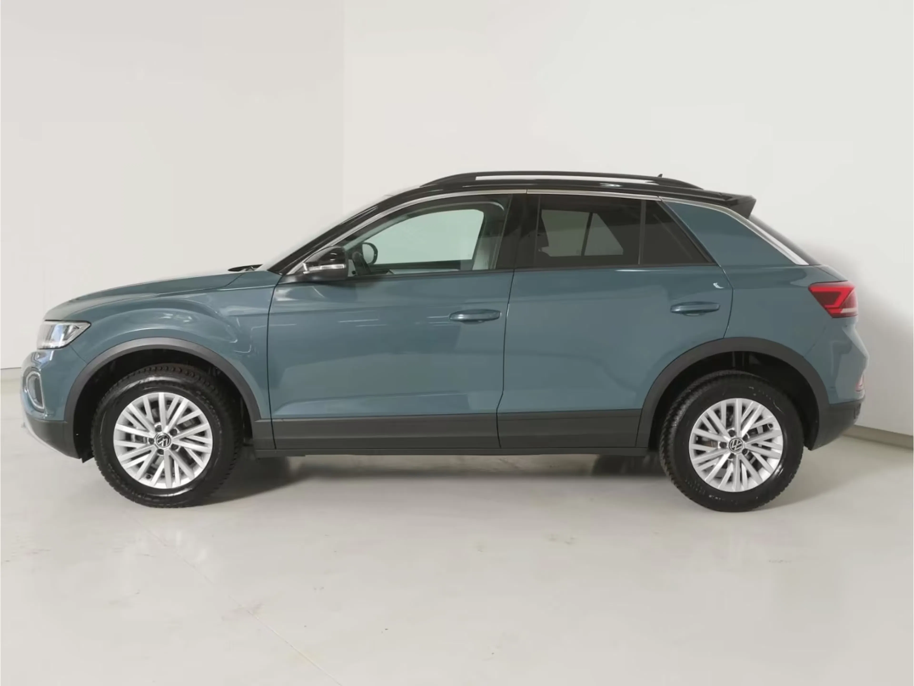 Ein in Blau-Metallic lackierter VW T-Roc steht auf einer Verkaufsfläche.