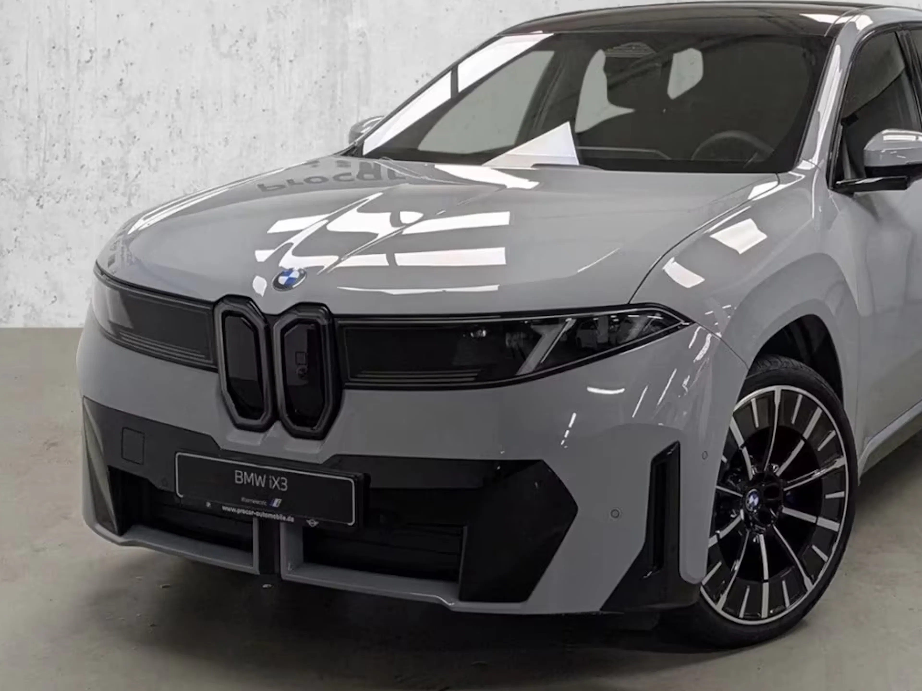 Ein BMW iX3 50 xDrive steht auf einer Verkaufsfläche.
