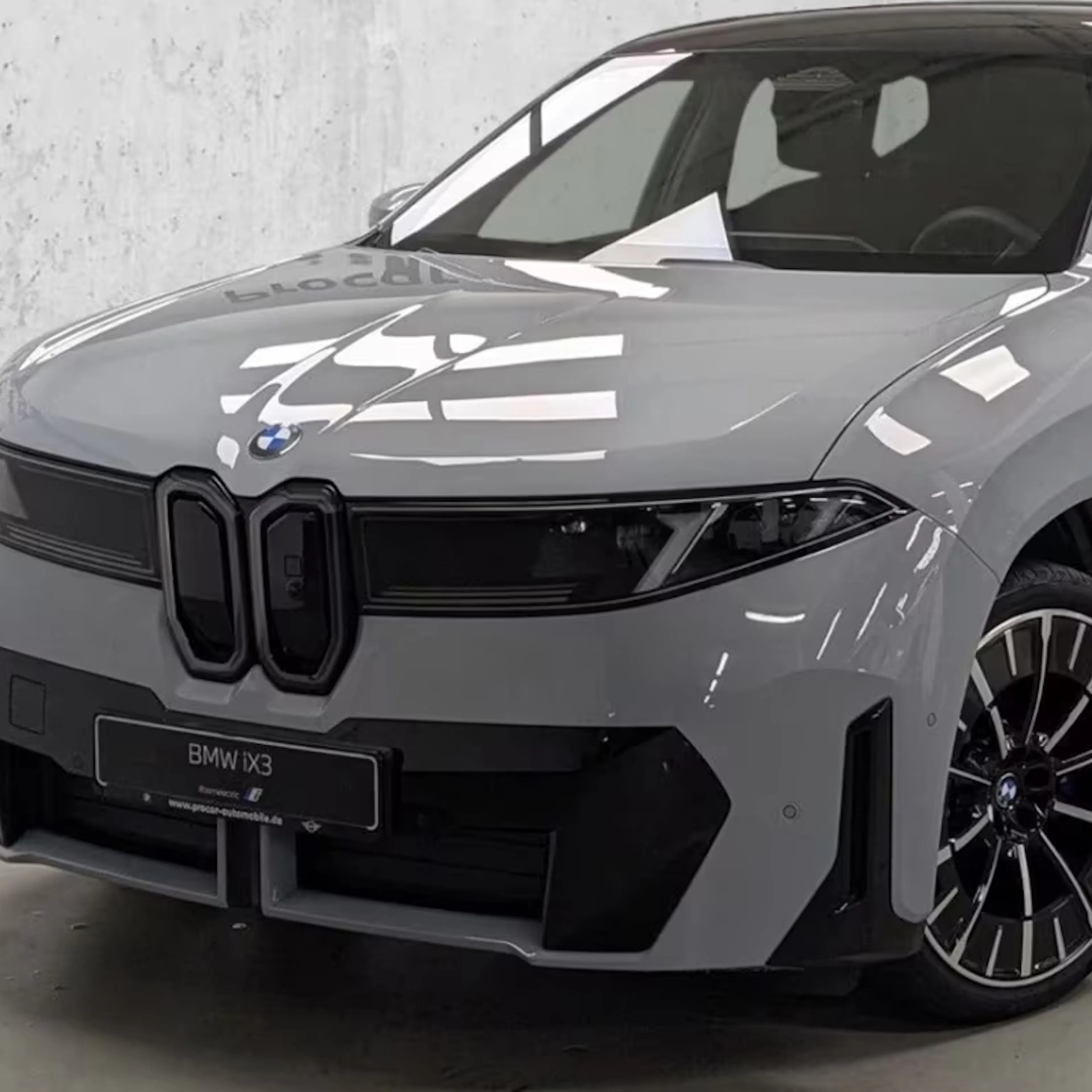 Ein BMW iX3 50 xDrive steht auf einer Verkaufsfläche.