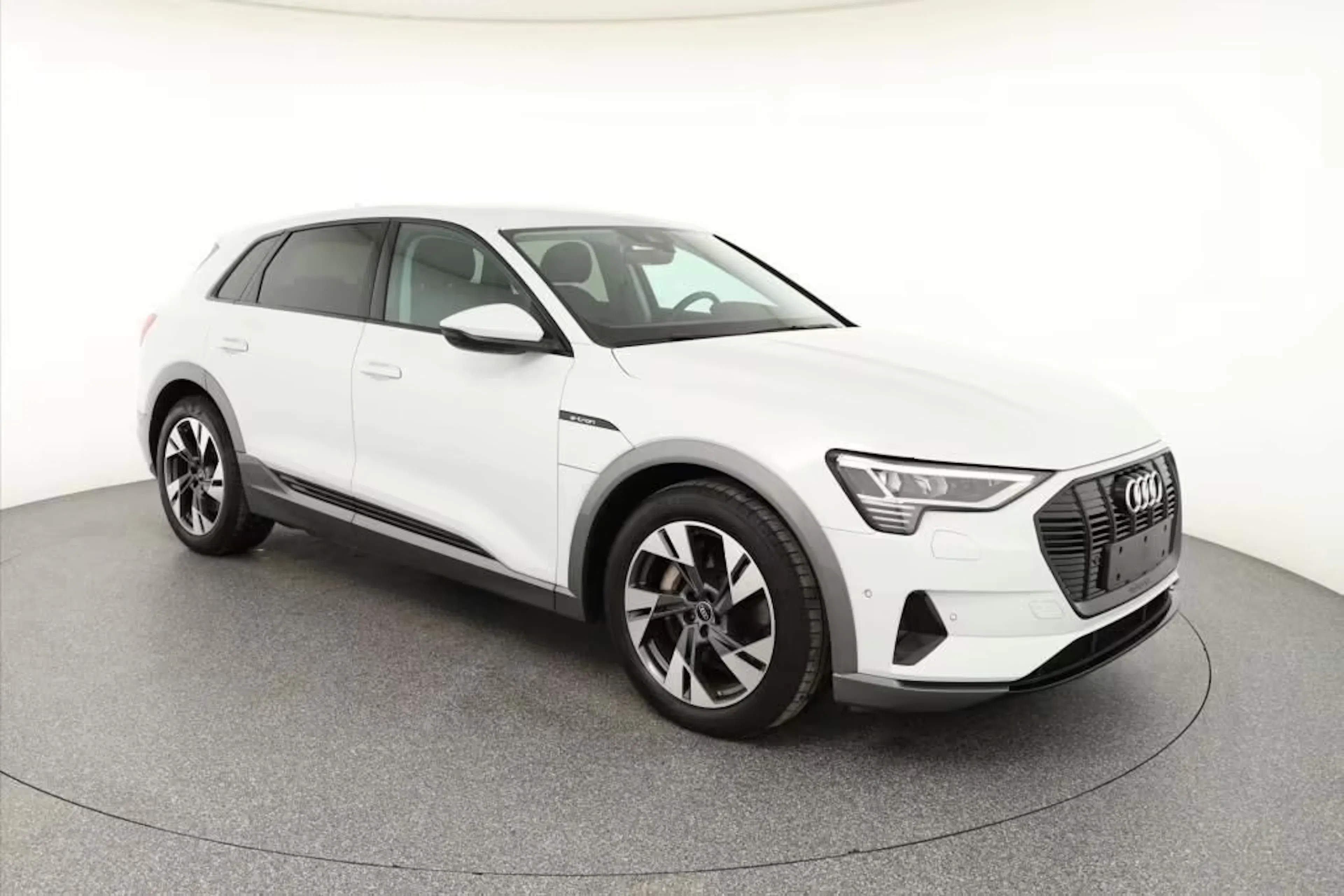 Ein weißer Audi e-tron steht auf einer Verkaufsfläche.