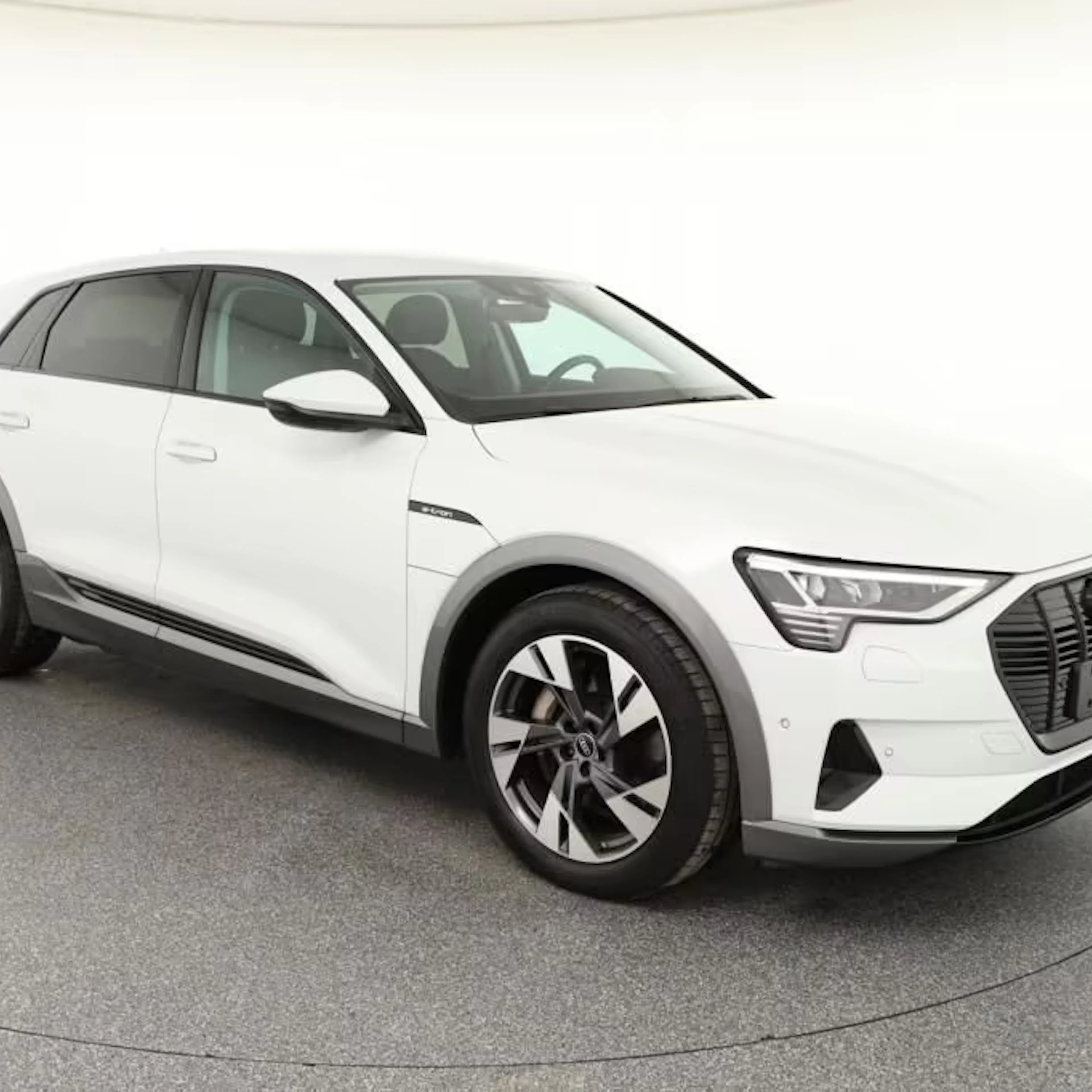 Ein weißer Audi e-tron steht auf einer Verkaufsfläche.