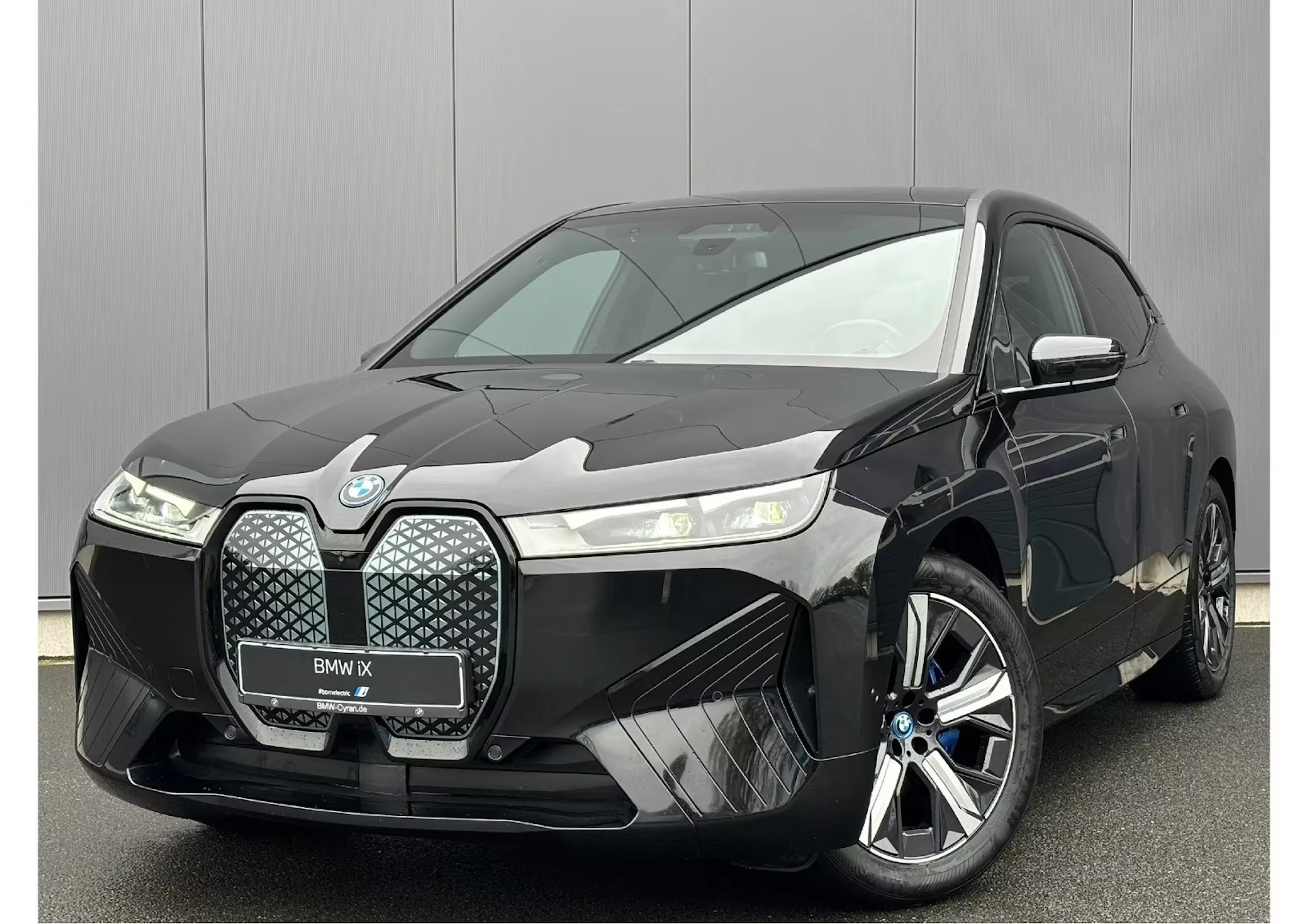 Ein schwarzer BMW iX steht auf einer Verkaufsfläche.