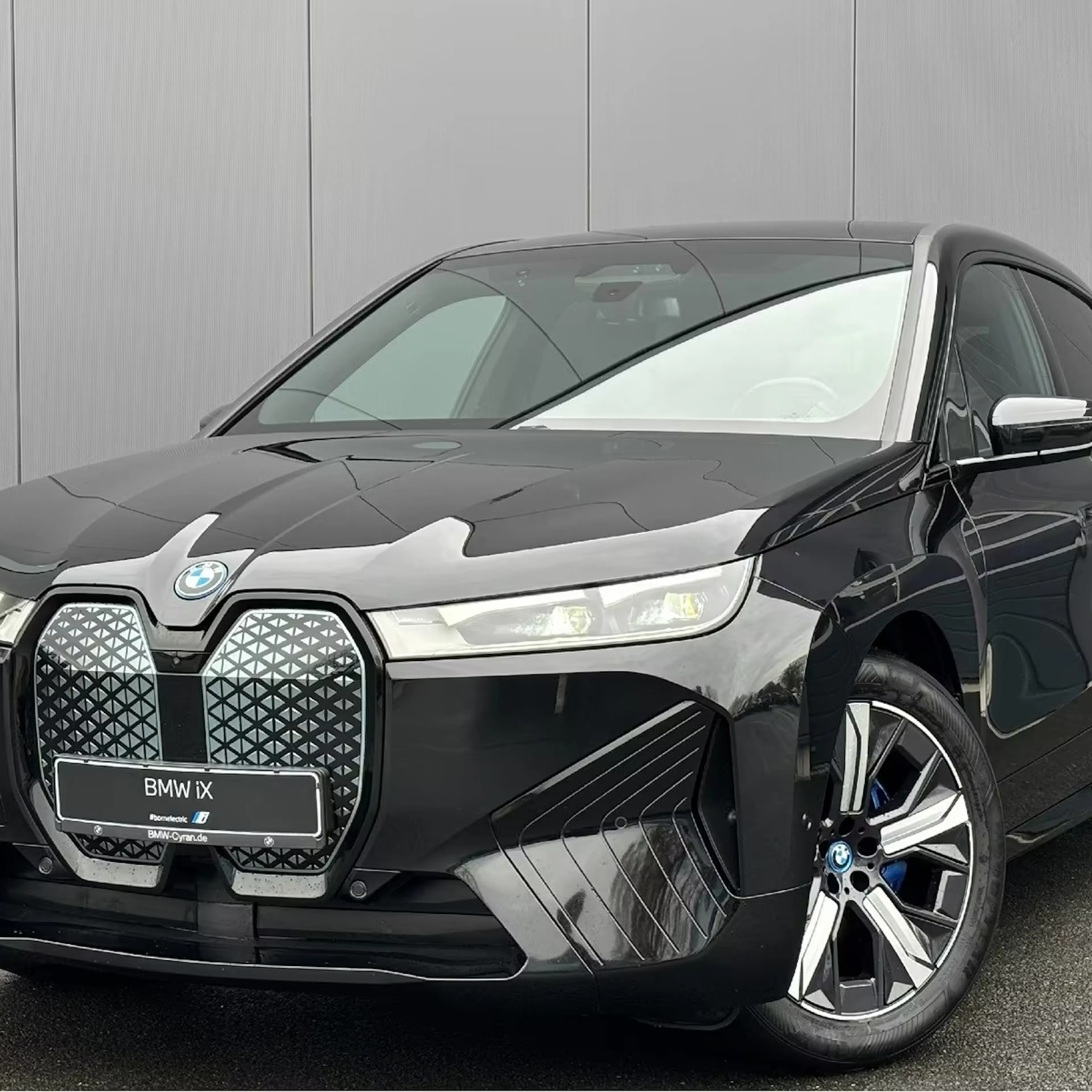 Ein schwarzer BMW iX steht auf einer Verkaufsfläche.