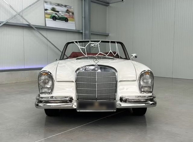 Ein weißer Mercedes-Benz 300, der früher dem Schauspieler James Mason gehörte, steht in einer Garage.