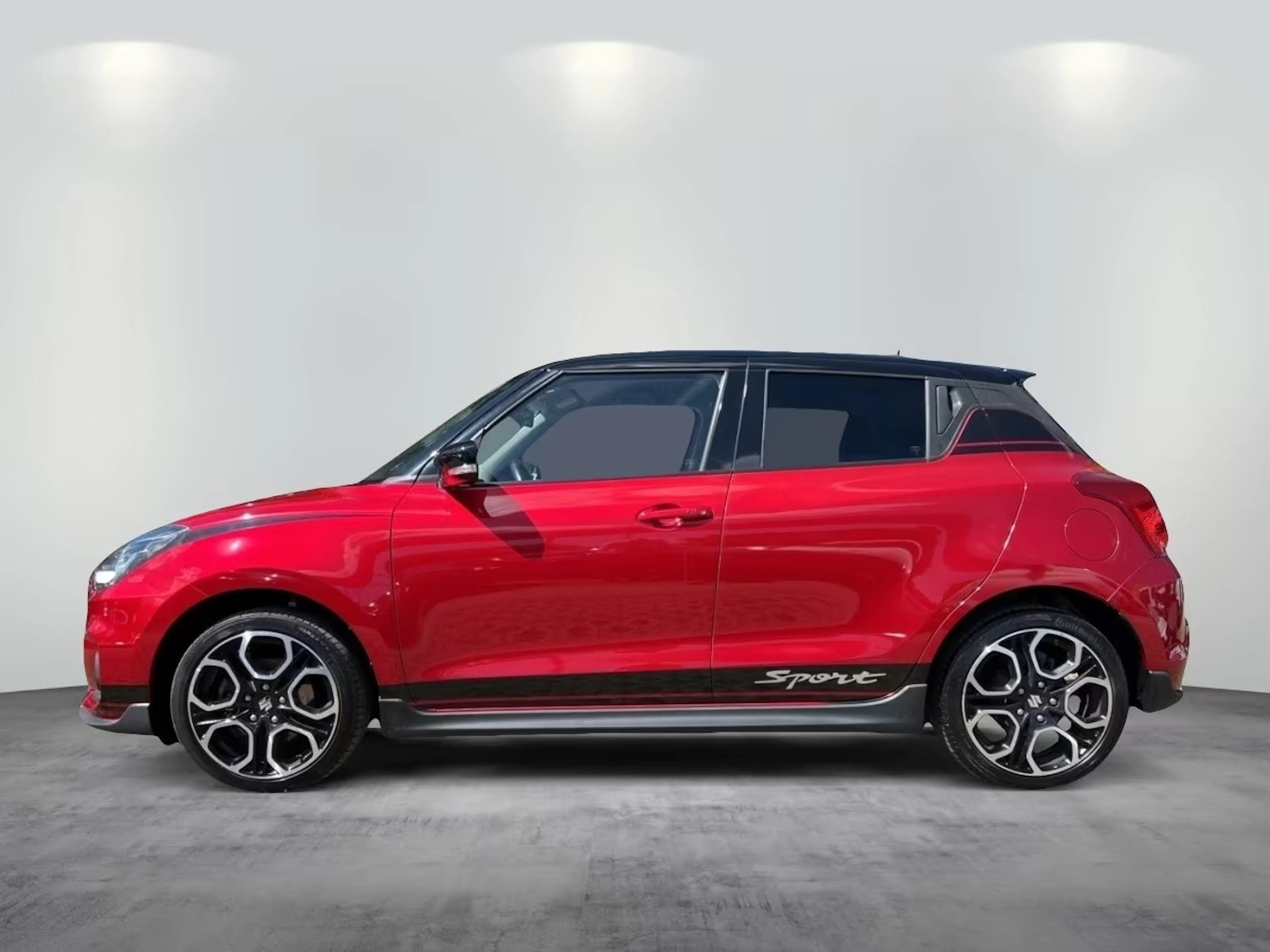 Ein roter Suzuki Swift Hybrid steht auf einer gepflasterten Fläche.