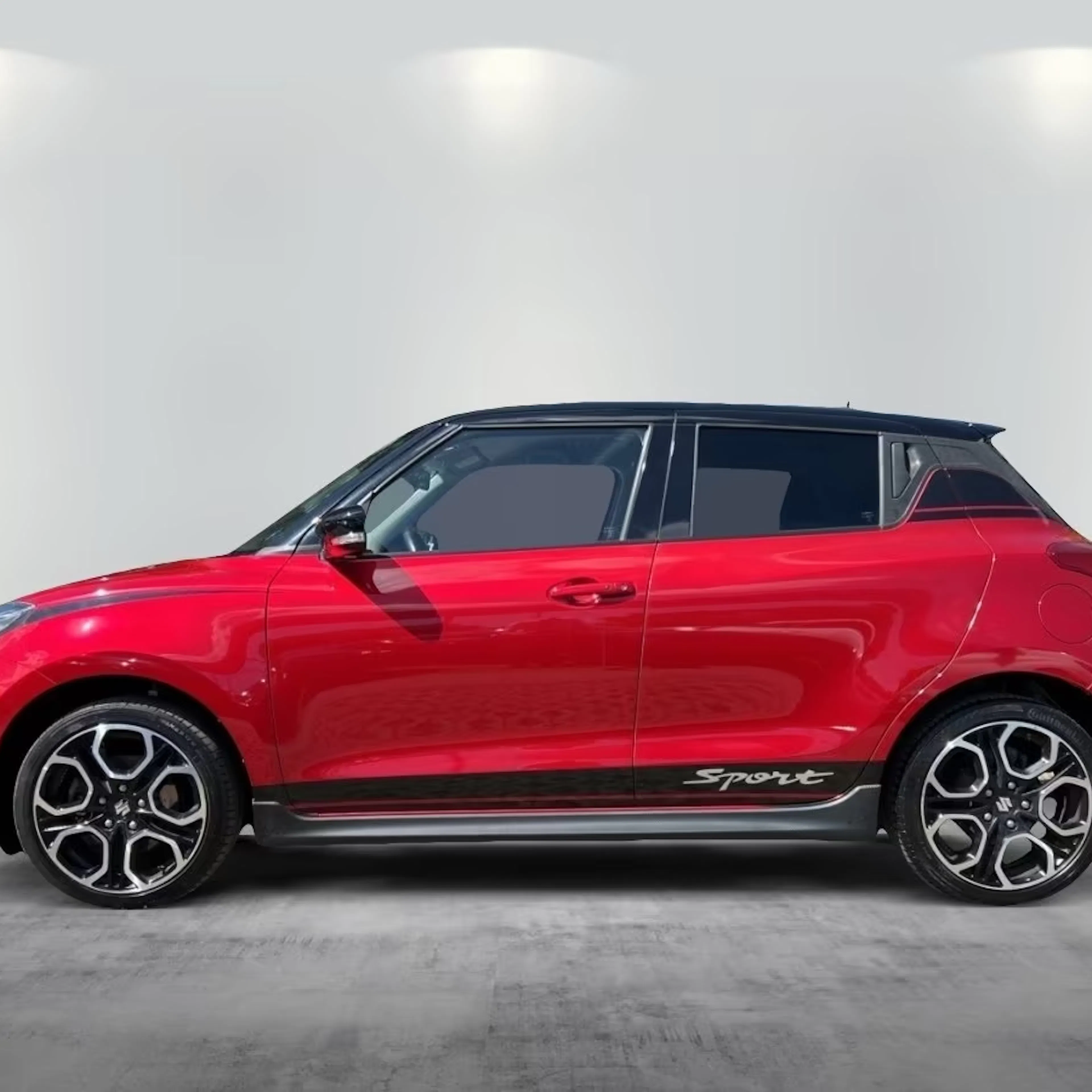 Ein roter Suzuki Swift Hybrid steht auf einer gepflasterten Fläche.