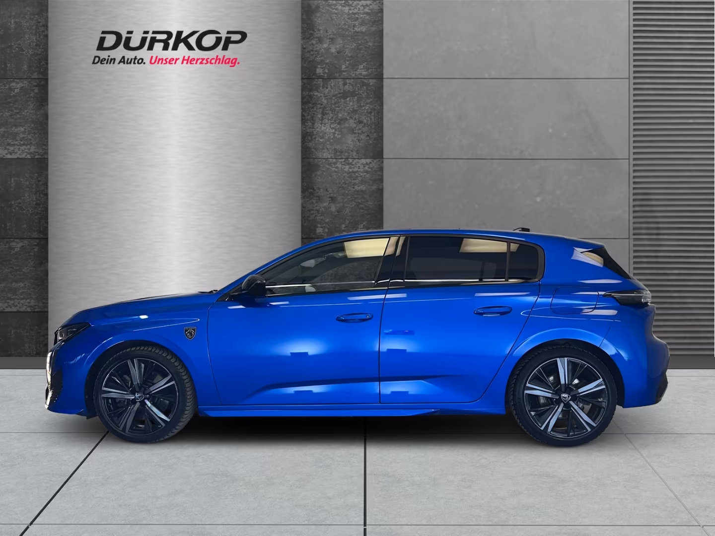 Ein blauer Peugeot 308 steht in einem Verkaufsraum.